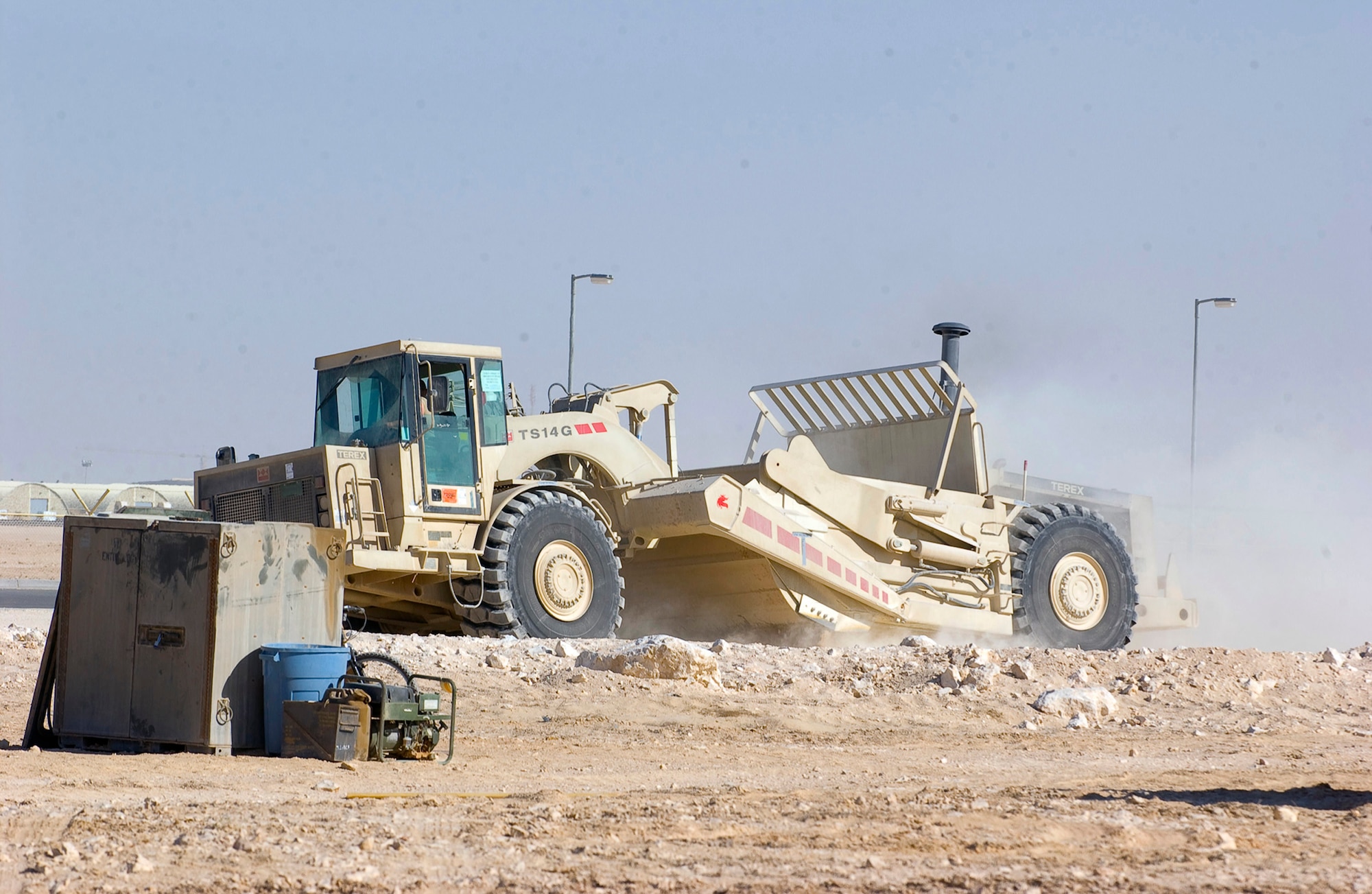 SOUTHWEST ASIA - Airman 1st Class Brandon Lynch, First Expeditionary RED HORSE Group, operates a scraper to shift dirt from a high spot of a pad site to fill in a low spot on the site at a Southwest Asia air base. (U.S. Air Force photo/Tech. Sgt. Sabrina Foster)