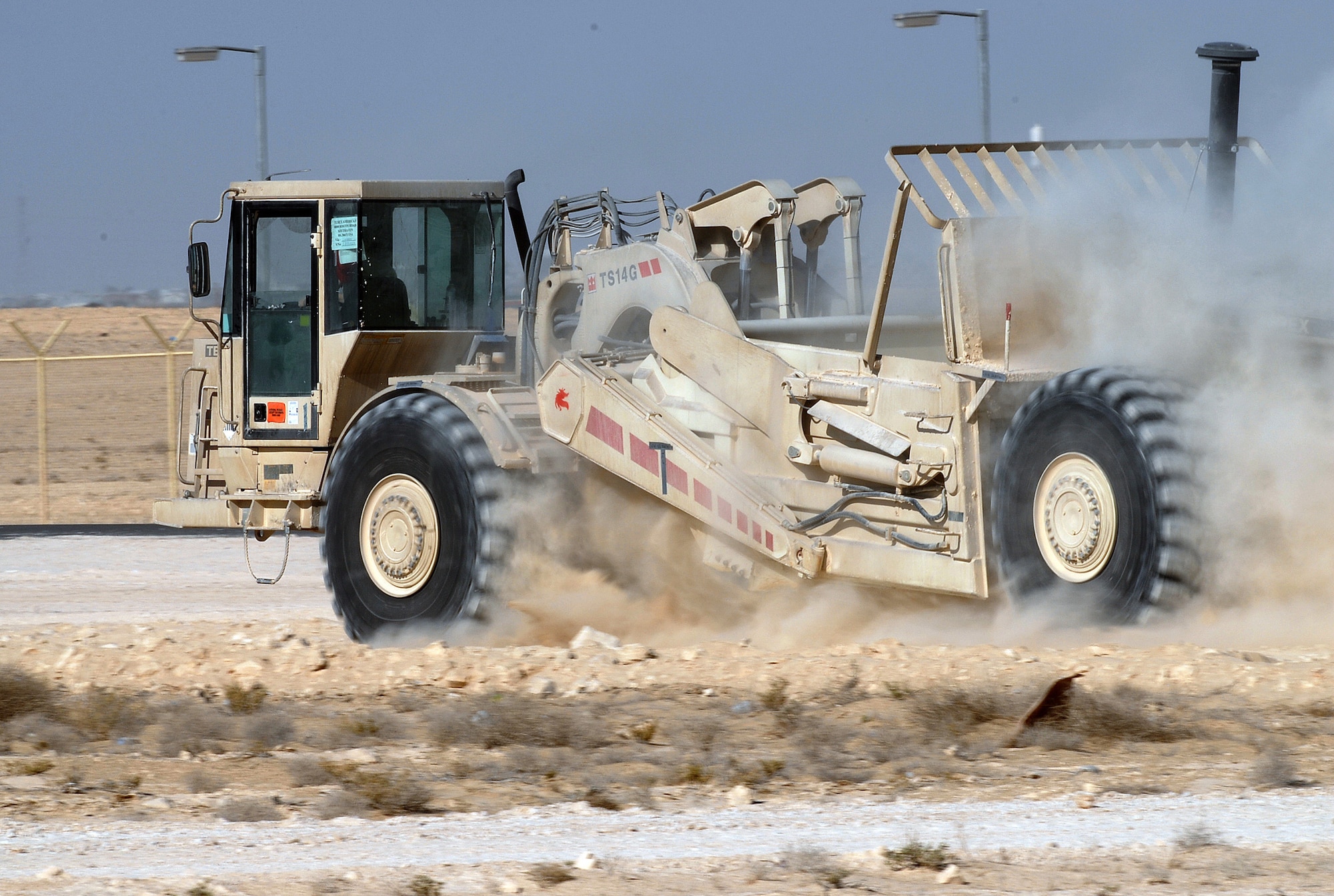 SOUTHWEST ASIA - Airman 1st Class Brandon Lynch, First Expeditionary RED HORSE Group, operates a scraper to shift dirt from a high spot of a pad site to a low spot on the site at a Southwest Asia air base. (U.S. Air Force photo/ Staff Sgt. Douglas Olsen)