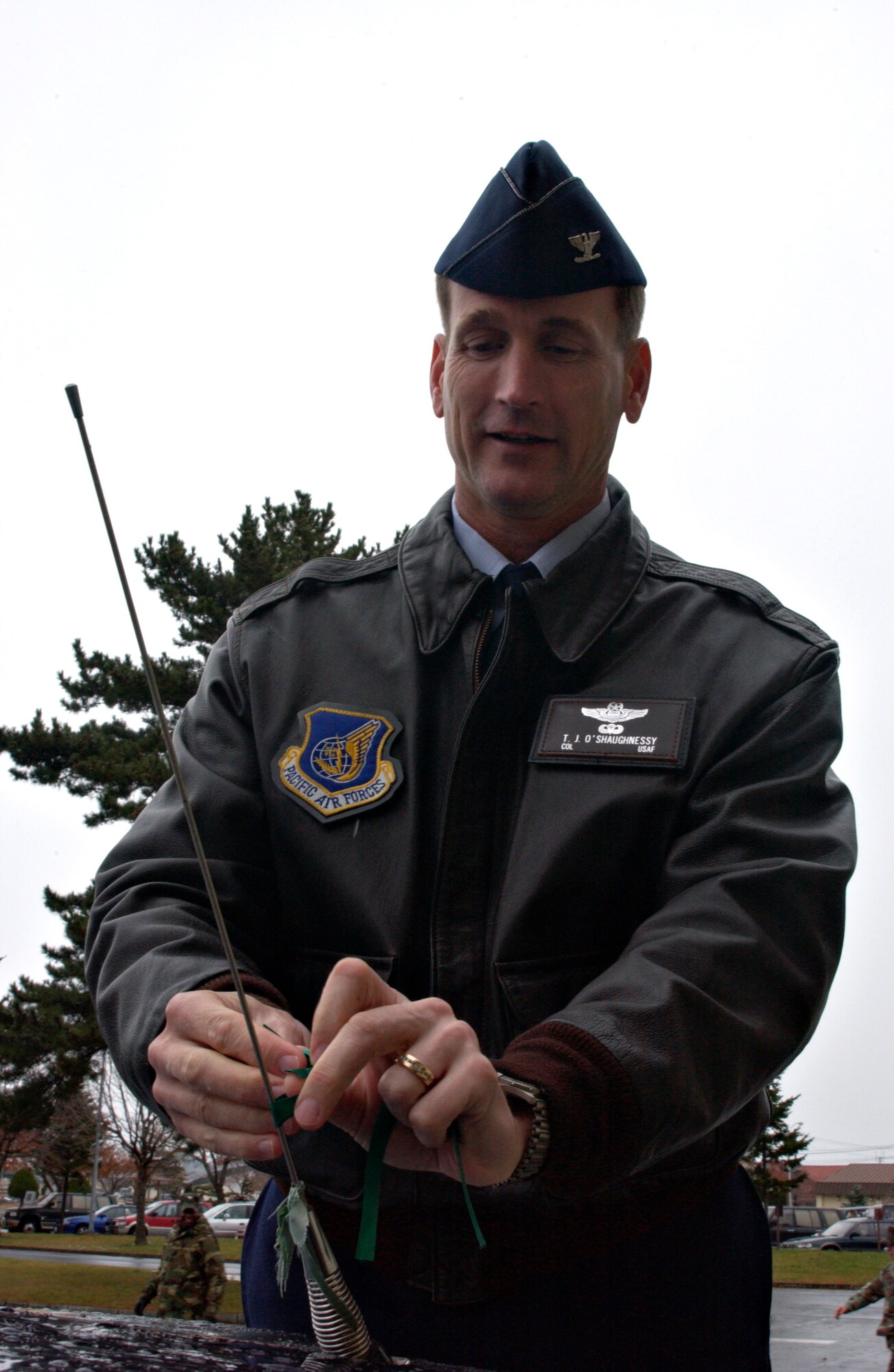 MISAWA AIR BASE, Japan -- Col. T.J. O'Shaughnessey, 35th Fighter Wing Commander, ties on the first ribbon for Misawa's annual Green Ribbon Campaign in the Base Exchange parking lot Nov. 21, 2007. Misawa holds the Green Ribbon Campaign to remind Airmen to have safety on their mind especially going into the holiday season. (US Air Force photo by Airman 1st Class Eric Harris)
