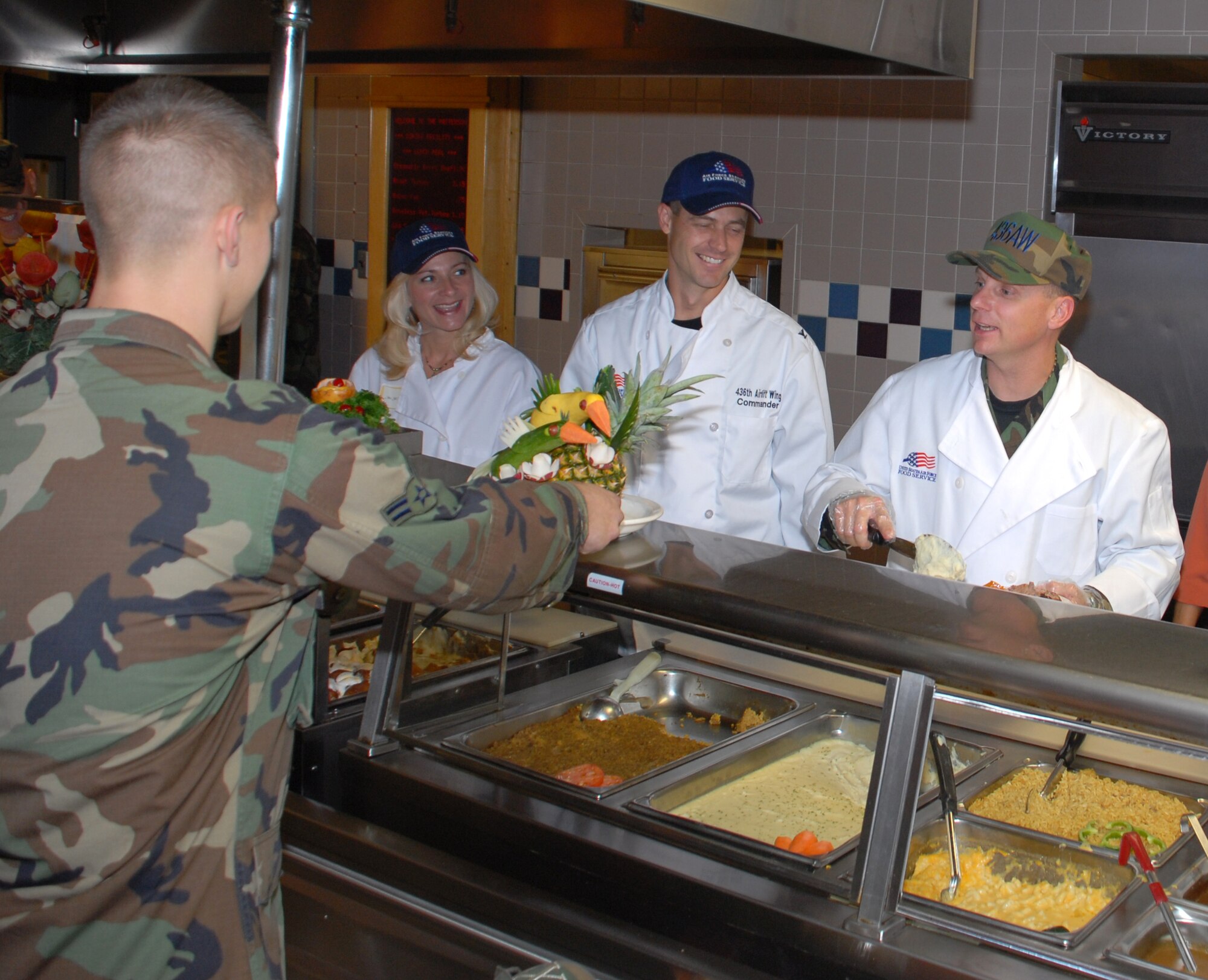Jill and Col. Steven Harrison, 436th Airlift Wing commander, and Chief Master Sgt. John Wood, 436th AW command chief serve a Thanksgiving meal to base Airmen. (U.S. Air Force photo/Tech. Sgt. Kevin Wallace)