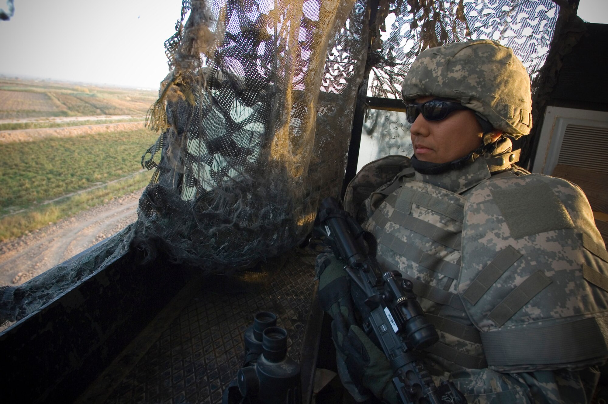 BALAD AIR BASE, Iraq -- Tech. Sgt. Roy Chavez, a 332nd Expeditionary Security Forces Squadron assistant alpha flight chief, surveys an open field beyond the perimeter of the flightline here on Nov. 22. Security Forces members remain vigilant for enemy attacks despite the Thanksgiving holiday. Sergeant Chavez is deployed from Whiteman Air Force Base, Mo. (U.S. Air Force photo/Tech. Sgt. D. Clare)