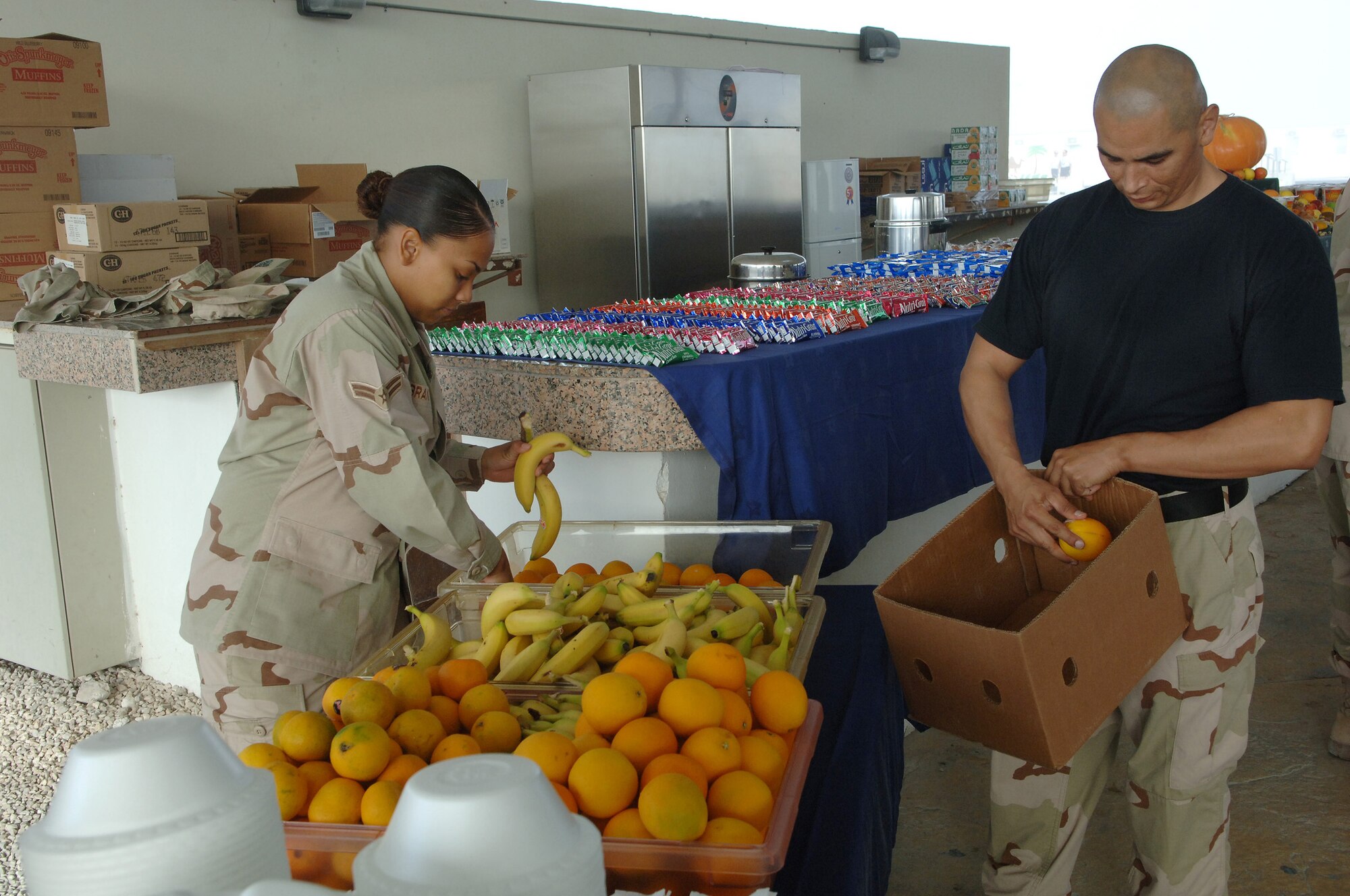 SOUTHWEST ASIA - Tech. Sgt. Rick Rayos and Airman 1st Class Dominique Brandt, 379th Expeditionary Services Squadron, lay out fresh fruit in preparation for the Thanksgiving day breakfast Nov. 22 in the Memorial Plaza at a Southwest Asia air base. Airman Brandt is deployed from Royal Air Forces Mildenhall, England and Sergeant Rayos is deployed from Nellis AFB, Nev. (U.S. Air Force Photo/Master Sgt.Greg Kunkle)