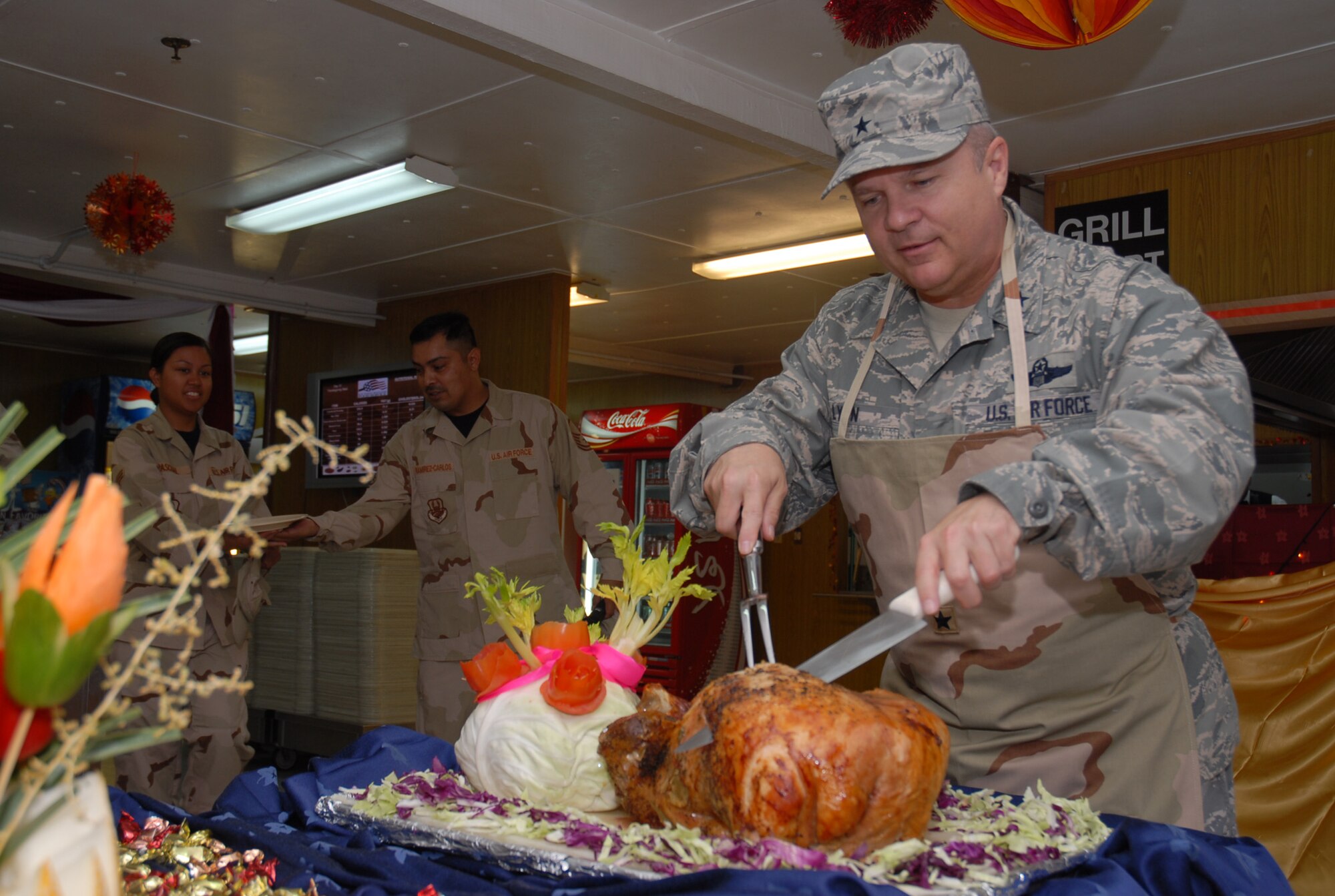 SOUTHWEST ASIA - Brig. Gen.Charlie Lyon, 379th Air Expeditionary Wing commander, makes the first cut on the Thanksgiving Day turkey at the Independence Dining Facility Nov. 22 at a Southwest Asia air base. (U. S. Air Force photo/Staff Sgt. Douglas Olsen)