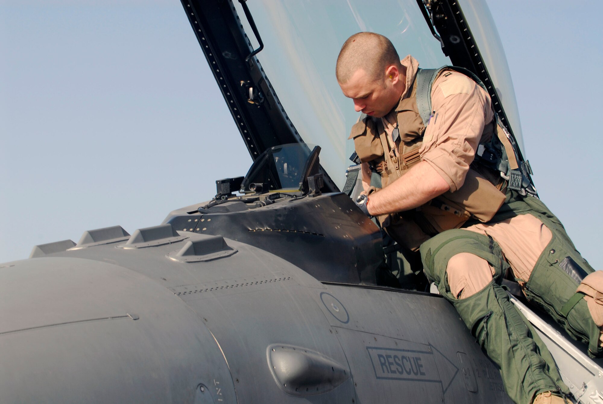 BALAD AIR BASE, Iraq -- Capt. Travis "Bandit" Keenan, a 22nd Expeditionary Fighter Squadron fighter pilot, preps the cockpit of an F-16 Fighting Falcon before launching on a combat mission here, Thanksgiving Day. Any discrepancies on the aircraft could halt a mission; preflight checks ensure any issues are addressed prior to takeoff. Captain Keenan is deployed from Spangdahlem AB, Germany. (U.S. Air Force photo/Staff Sgt. Joshua Garcia)