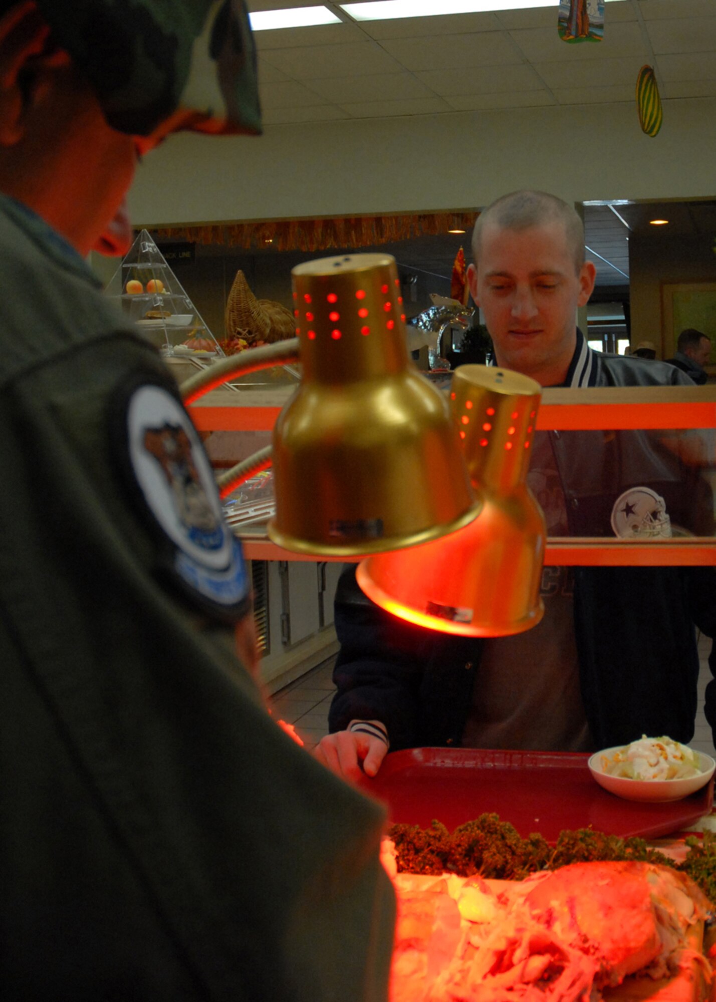 KUNSAN AIR BASE, South Korea—  Gen. Paul V. Hester, Pacific Air Forces commander, serves turkey to Senior Airman Curtis Morgan, 8th Maintenance Squadron here Nov. 22. General Hester served and ate Thanksgiving dinner with Airmen stationed at Kunsan to show his appreciation for their service.  (U.S. Air Force Photo/Staff Sgt. Araceli Alarcon) 