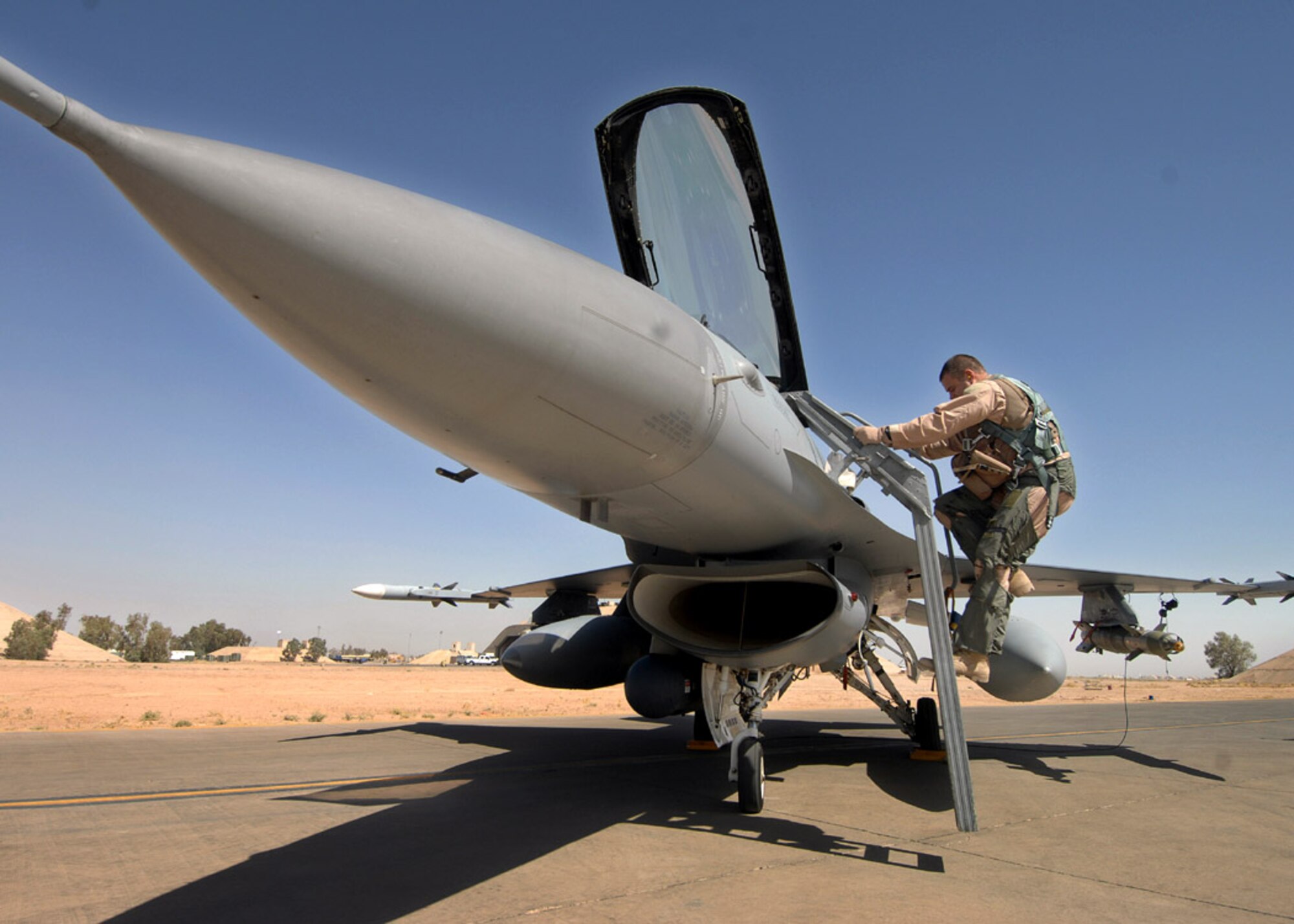 Maj. Brian Chamness climbs into an F-16 Fighting Falcon to fly a combat mission in support of Operation Iraqi Freedom.  Major Chamness is with the 332nd Expeditionary Fighter Squadron at Balad Air Base, Iraq. (U.S. Air Force photo/Tech. Sgt Rick Sforza)