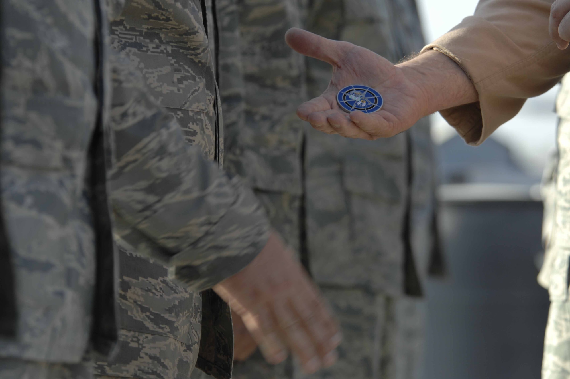 BAGRAM AIR BASE, Afghanistan - Lt. Gen. Gary North, Commander of U.S. Central Command Air Forces, coins an Airmen here during a visit here Nov. 22, 2007.  Both General North and CENTAF Command Chief, Chief Master Sgt. Richard Small came here to thank Airmen for their service.