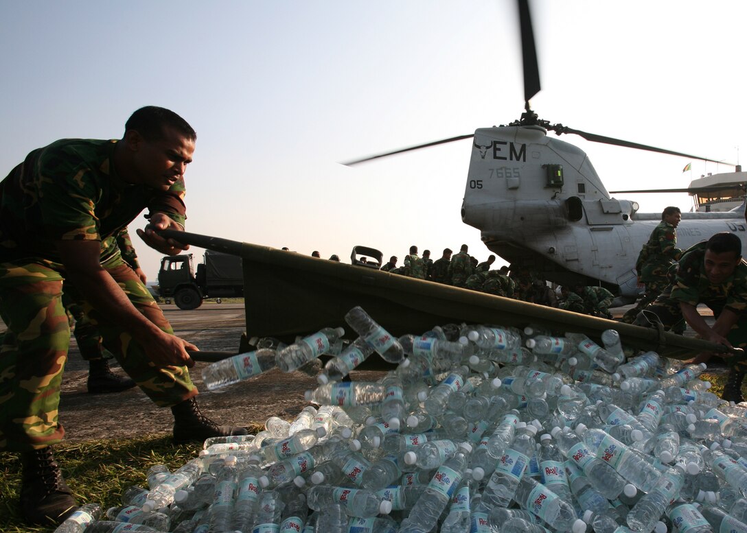 Bangladeshi soldiers use a stretcher to unload a shipment of bottled water delivered by Marines of Marine Medium Helicopter Squadron 261 (Reinforced), the aviation element of the 22nd Marine Expeditionary Unit (Special Operations Capable), in  Barisal, Bangladesh, Nov. 23, 2007. This mission marked the first US military aid arriving in Bangladesh. USS Kearsarge and the 22nd MEU (SOC) are supporting relief operations at the request of the Government of Bangladesh. (Official U.S. Marine Corps photo by Cpl. Peter R. Miller)