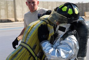 BALAD AIR BASE, Iraq -- Capt. Deborah Travis, 732nd Expeditionary Support Squadron director of operations, carries a fire hose during the Balad Firefighter Challenge here, Nov. 24. Participants in the competition competed in several different team events as well some solo challenges. Captain Travis is deployed from Langley Air Force Base, Va. (U.S. Air Force photo/Staff Sgt. Joshua Garcia)