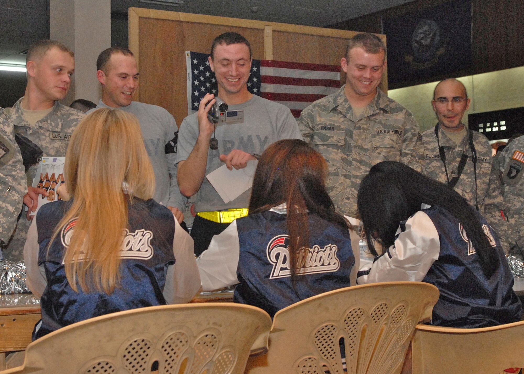 Servicemembers at Balad Air Base, Iraq are all smiles while meeting the New England Patriots Cheerleaders during the Operation Season's Greetings 2007 show. Many stood in line two hours following the show to meet the cheerleaders and other entertainers. (U.S. Air Force photo/Ken Hackman)
