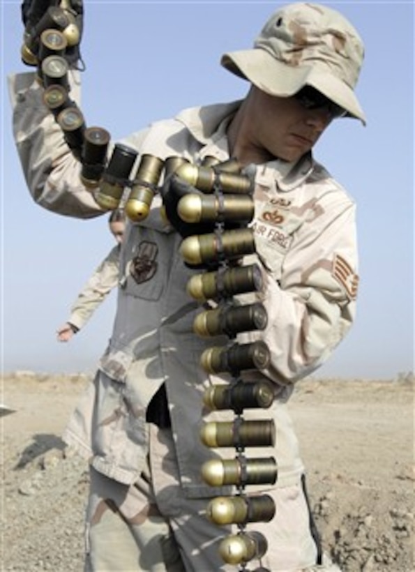 U.S. Air Force Staff Sgt. Anthony Pousen picks up M-430 High Explosive dual-purpose grenade rounds from their case on Ali Air Base, Iraq, on Nov. 14, 2007.  Pousen is assigned to the 407th Expeditionary Civil Engineer Squadron explosive ordnance disposal team, which unloaded nearly 1,800 pounds of expired munitions for demolition to ensure they will not be used against U.S. forces.  
