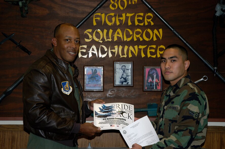 KUNSAN AIR BASE, South Korea --  Colonel CQ "Wolf" Brown, 8th Fighter Wing commander, congratulates Airman 1st Class Antonio Evangelista, 8th Aircraft  Maintenance Squadron aircraft armament weapons specialist, here Nov. 19. Airman Evangelista was recognized as the wing's Pride of the Pack for the week of Nov. 19. (U.S. Air Force photo/Staff Sgt Alice Moore) 