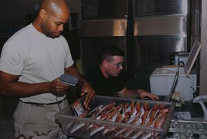 SPUTHWEST ASIA - Tech. Sgt. Joseph Pinkney (left) and Senior Airman Thomas Sullivan, 379th Expeditionary Medical Group Blood Transhipment Center, use the defense blood standard system to scan and track blodd products that are being shipped to Balad Air Base, Iraq. (U.S. Air Force photo/Staff Sgt. Doug Olsen)