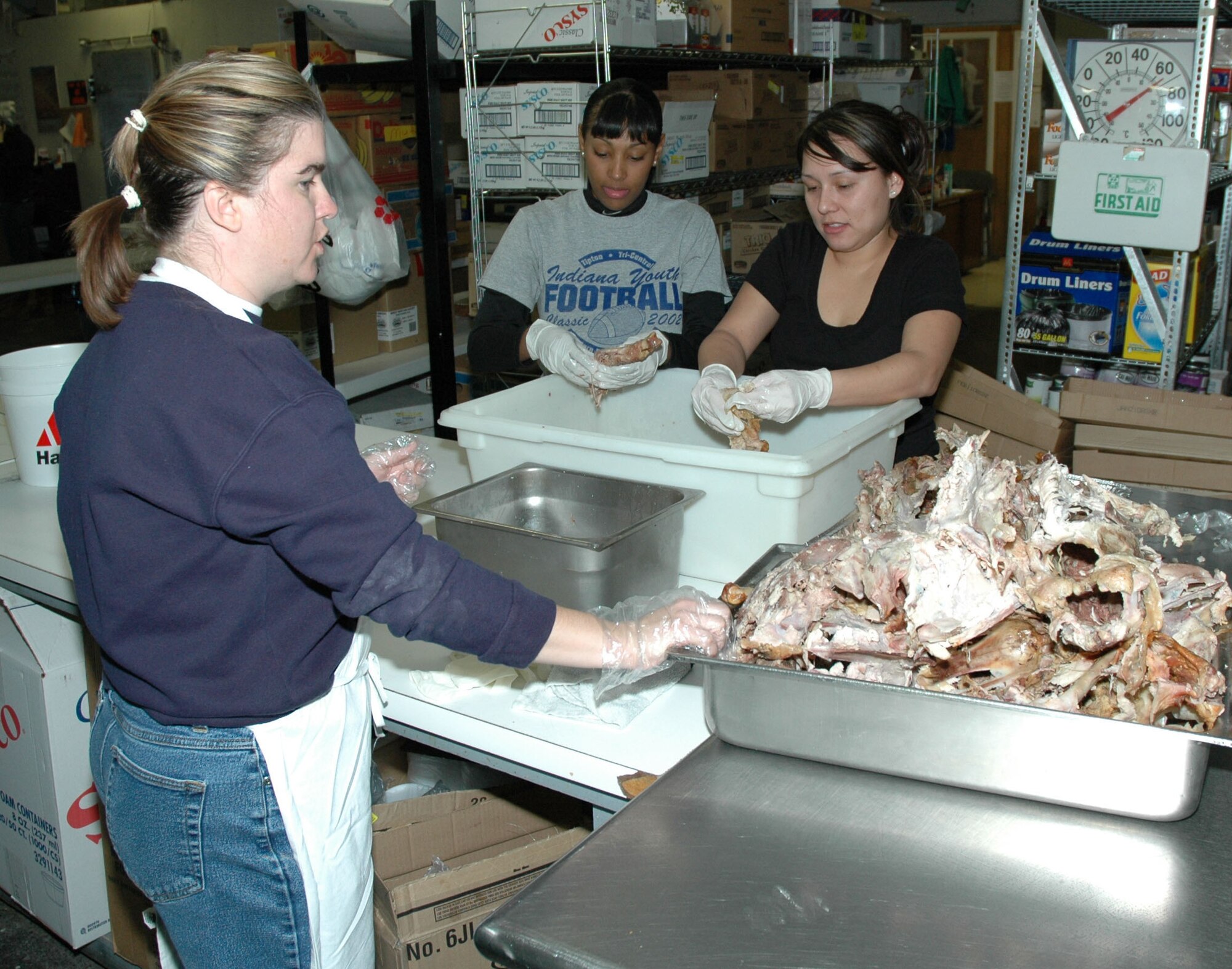 1st Lt. Jennifer Hubal, 341st Mission Support Squadron relocations and employment chief; Airman 1st Class Krystle Requenes, 341st MSS separations technician; and Senior Airman Connie Rodriguez, 341st MSS evaluations technician, finish preparing turkey for Meals on Wheels’ Operation Thanksgiving. Airmen from Malmstrom also delivered meals to less fortunate members of the Great Falls community on Thanksgiving Day.(U.S. Air Force photo/Airman 1st Class Dillon White)