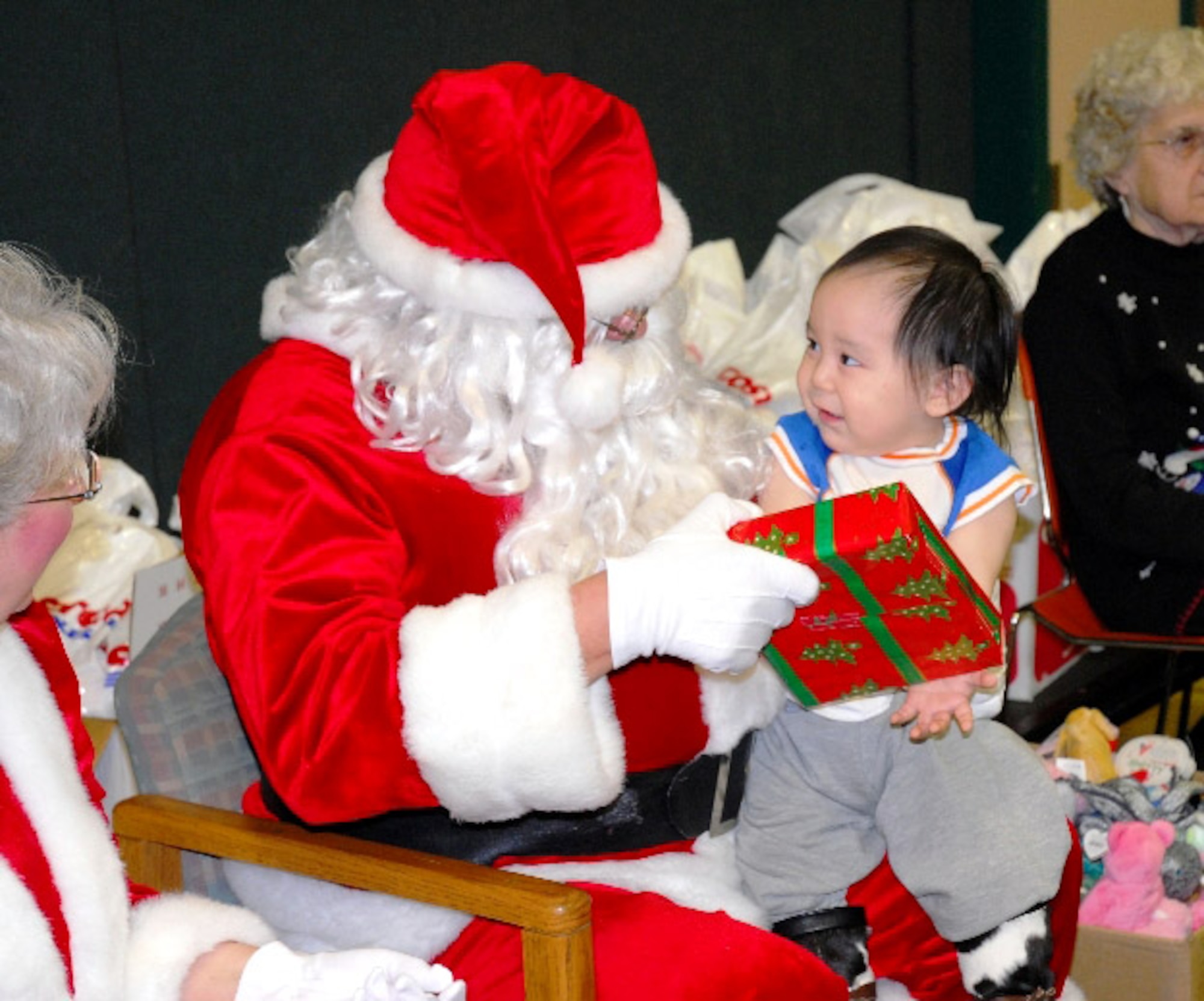 Richard Nashoalook of Wainwright, Alaska, smiles as he receives a gift from Santa Claus during Operation Santa Claus Nov. 26. The Alaska National Guard program delivers school supplies, presents and Santa Claus and Mrs. Claus to rural villages across the state. (U.S. Air Force photo/Capt. Guy Hayes)
