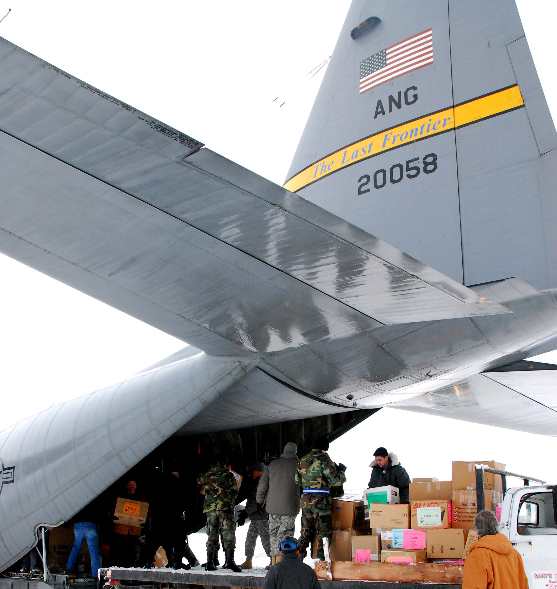 Alaska National Guard Soldiers and Airmen join other volunteers in unloading gifts and goodies off the back of a C-130 Hercules during Operation Santa Claus Nov. 13 in Togiak, Alaska. Alaska National Guard members are bringing Christmas early to children in remote Alaskan villages. (U.S. Army photo/Sgt. Karima Turner)