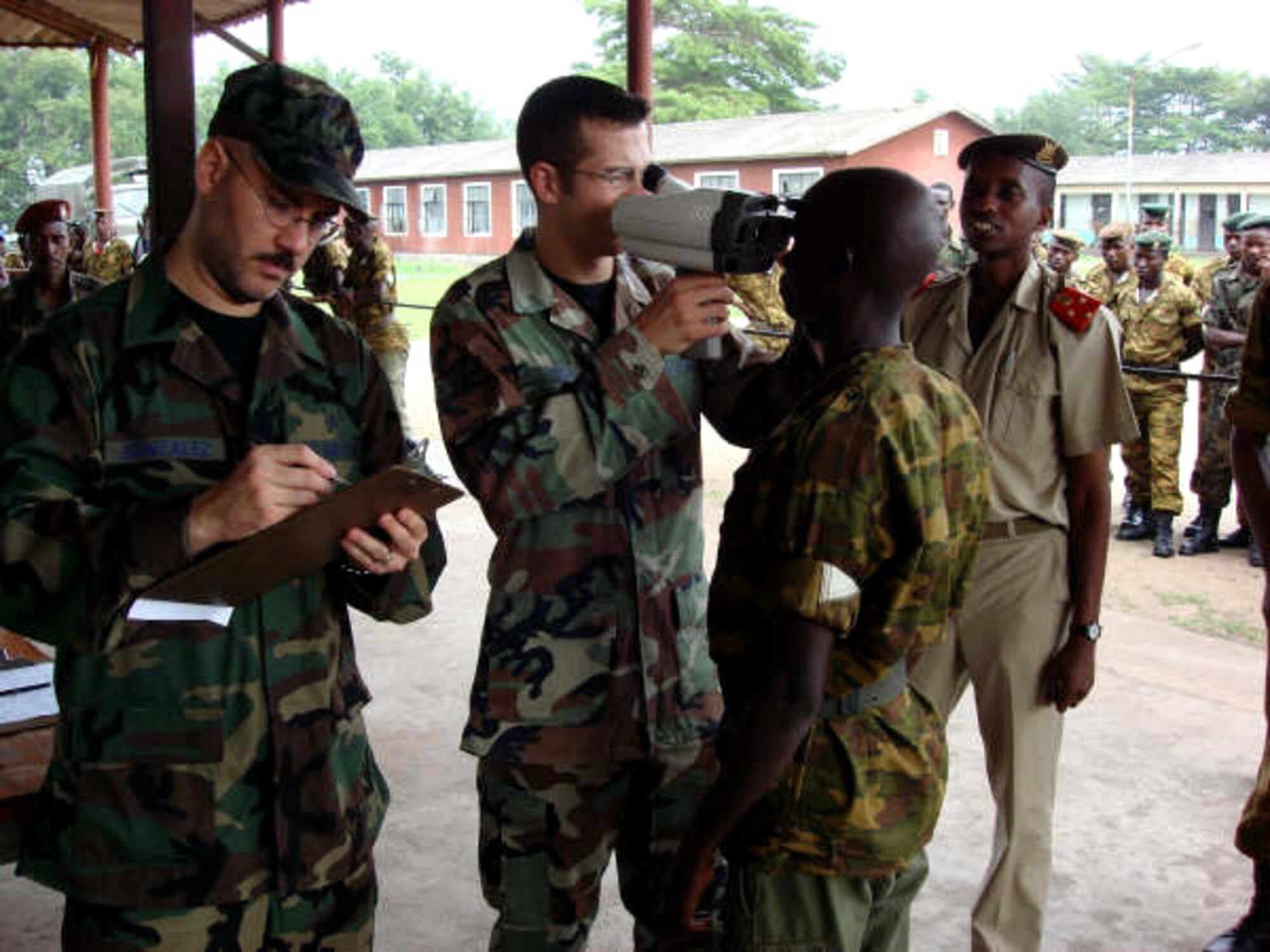 Tech. Sgt. Luis Gonzales and Senior Airman Dale King perform a preliminary test on a troop at Gakumbu military base, Africa. The Airmen were part of a team sent to povide optometry and eye care Nov. 6 to 15 to two battalions from the Burundi, Africa, military who were preparing to deploy on a peacekeeping mission to Somalia. Sergeant Gonzales is assigned to the 52nd Aerospace Medicine Squadron at Spangdahlem Air Base, Germany, and Airman King is assigned to the 435th Aerospace Medicine Squadron at Ramstein Air Base, Germany. (Courtesy photo)