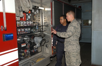 Trainee Michael Nieman, 320th Training Squadron, gets a personal tour of Engine 19 at fire station 19 on Vance Jackson Road by firefighter Joe Brown. Trainee Nieman was one of 20 basic trainees adopted by 10 area fire stations on Thanksgiving Day as part of Operation Homecooking. (USAF photo by Alan Boedeker)                          