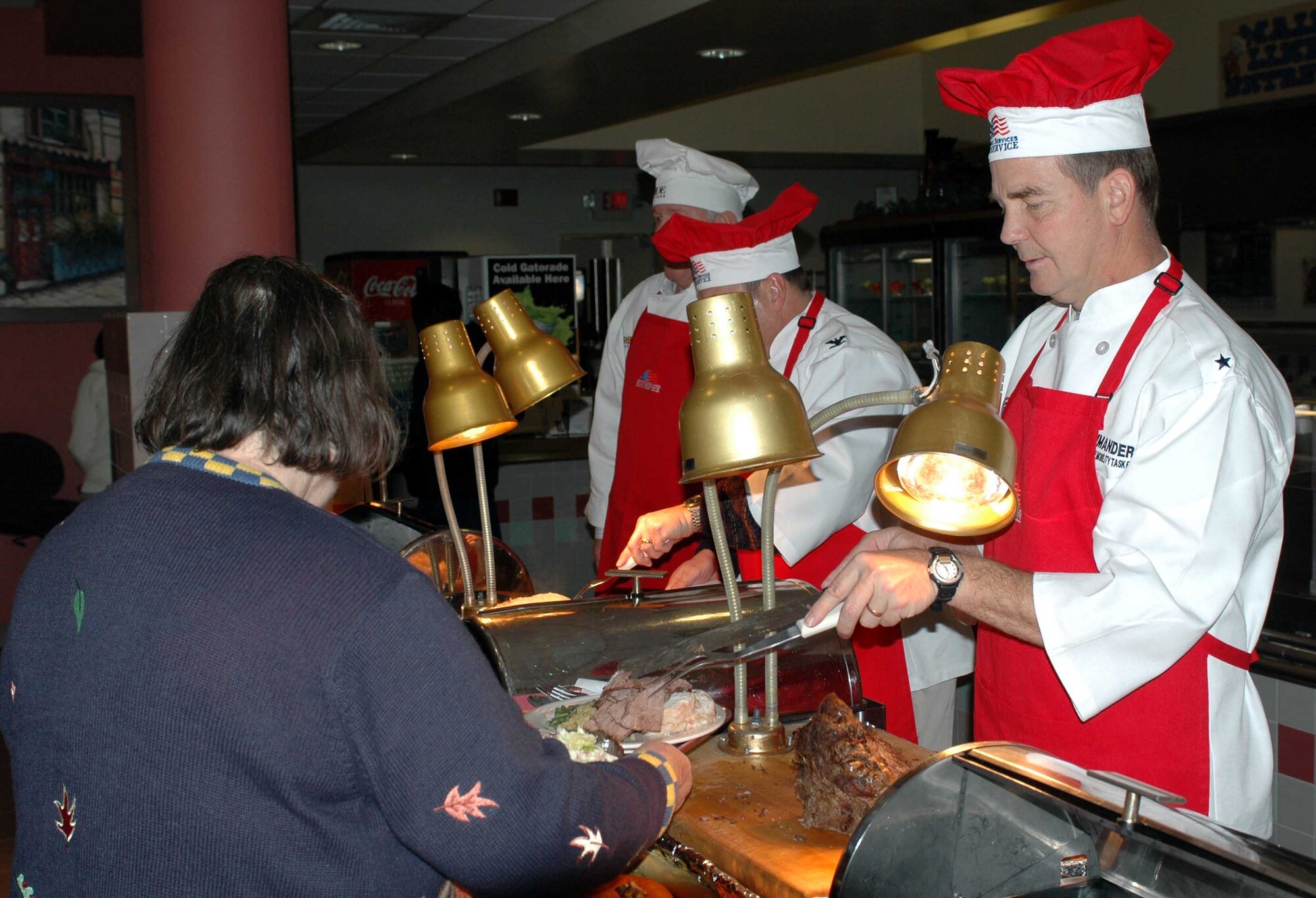 Brig. Gen. Mark Stearns, 15th Expeditionary Mobility Task Force commander, serves a Thanksgiving Day meal to a customer at the Sierra Inn Dining Facility. Airmen, Retirees and family members were able to enjoy a festive meal served by Team Travis leadership. (U.S. Air Force photo/Senior Airman Shaun Emery)