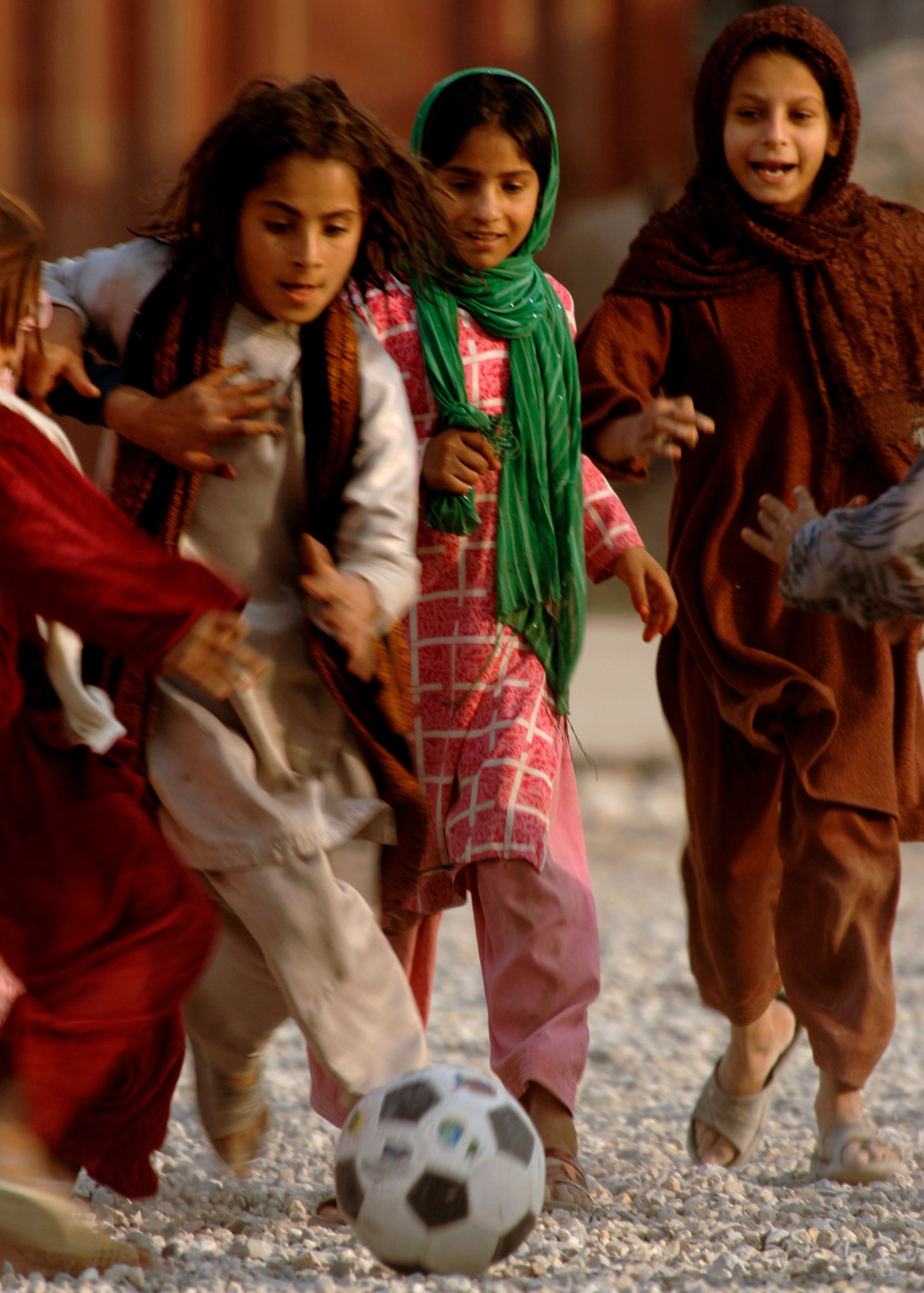 Afghan girls chase after a soccer ball during a game between children from the local community American servicemembers from the Nangarhar Provincial Reconstruction Team Nov. 9 at a forward operating base in Jalalabad, Afghanistan. The Nangarhar PRT is a joint team of Airmen, Soldiers and representatives from the U.S. Department of State, U.S. Agency for International Development and the U.S. Department of Agriculture. The team is responsible for helping the Islamic Republic of Afghanistan government improve security, governance and promote reconstruction in the Nangarhar Province. PRT members assess community needs and then builds schools, government centers, roads, medical capability and basic infrastructure throughout Nangarhar. Unit members also mentor Afghan government officials and security forces to provide the Afghan people with the state representation and security they need. (U.S. Air Force photo/Staff Sgt. Joshua T. Jasper) 
