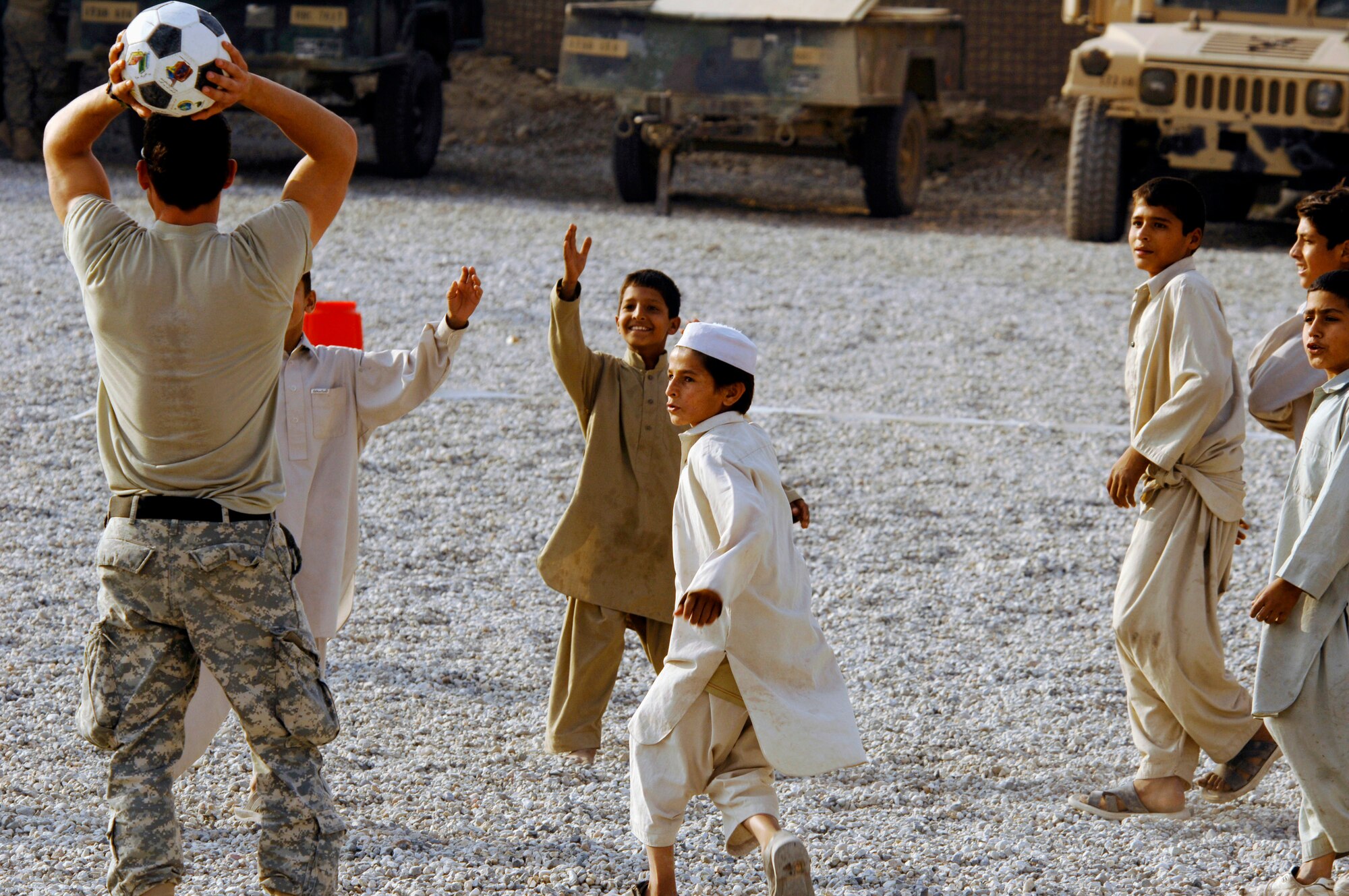Army and Air Force members from the Nangarhar Provincial Reconstruction Team and Afghan children play soccer together Nov. 9 at the PRT forward operating base in Jalalabad, Afghanistan. The Nangarhar PRT is a joint team of Airmen, Soldiers and representatives from the U.S. Department of State, U.S. Agency for International Development and the U.S. Department of Agriculture. The team is responsible for helping the Islamic Republic of Afghanistan government improve security, governance and promote reconstruction in the Nangarhar Province. PRT members assess community needs and then builds schools, government centers, roads, medical capability and basic infrastructure throughout Nangarhar. Unit members also mentor Afghan government officials and security forces to provide the Afghan people with the state representation and security they need. (U.S. Air Force photo/Staff Sgt. Joshua T. Jasper)
