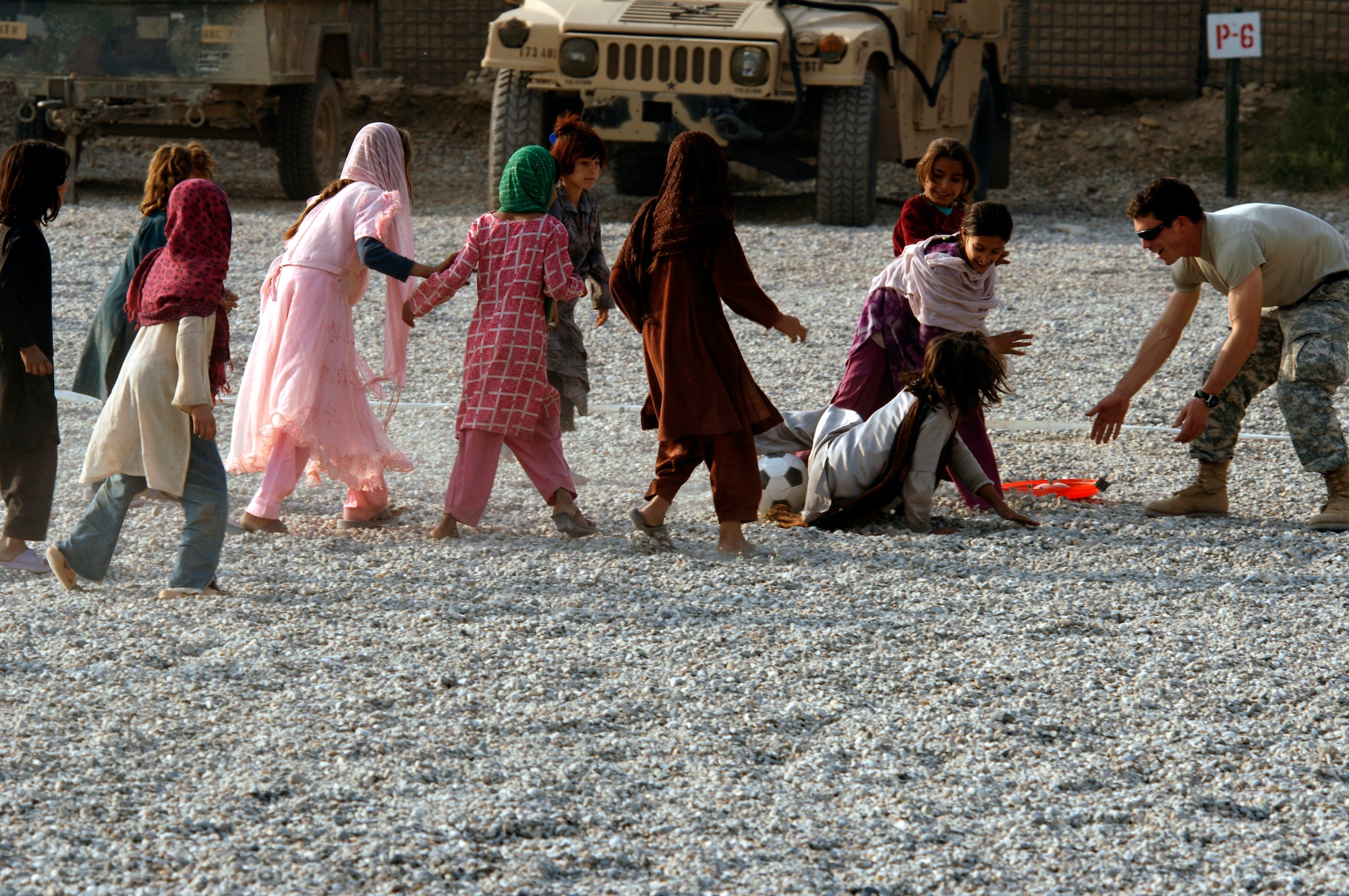 Army and Air Force members from the Nangarhar Provincial Reconstruction Team and Afghan children play soccer together Nov. 9 at the PRT forward operating base in Jalalabad, Afghanistan. The Nangarhar PRT is a joint team of Airmen, Soldiers and representatives from the U.S. Department of State, U.S. Agency for International Development and the U.S. Department of Agriculture. The team is responsible for helping the Islamic Republic of Afghanistan government improve security, governance and promote reconstruction in the Nangarhar Province. PRT members assess community needs and then builds schools, government centers, roads, medical capability and basic infrastructure throughout Nangarhar. Unit members also mentor Afghan government officials and security forces to provide the Afghan people with the state representation and security they need. (U.S. Air Force photo/Staff Sgt. Joshua T. Jasper)
