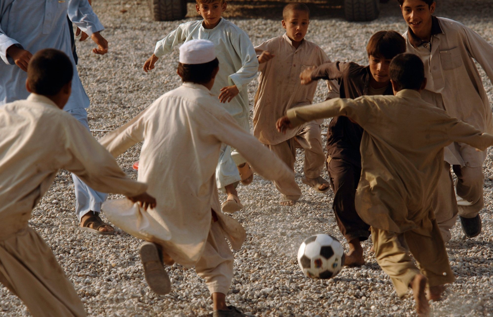 Army and Air Force members from the Nangarhar Provincial Reconstruction Team and Afghan children play soccer together Nov. 9 at the PRT forward operating base in Jalalabad, Afghanistan. The Nangarhar PRT is a joint team of Airmen, Soldiers and representatives from the U.S. Department of State, U.S. Agency for International Development and the U.S. Department of Agriculture. The team is responsible for helping the Islamic Republic of Afghanistan government improve security, governance and promote reconstruction in the Nangarhar Province. PRT members assess community needs and then builds schools, government centers, roads, medical capability and basic infrastructure throughout Nangarhar. Unit members also mentor Afghan government officials and security forces to provide the Afghan people with the state representation and security they need. (U.S. Air Force photo/Staff Sgt. Joshua T. Jasper)
