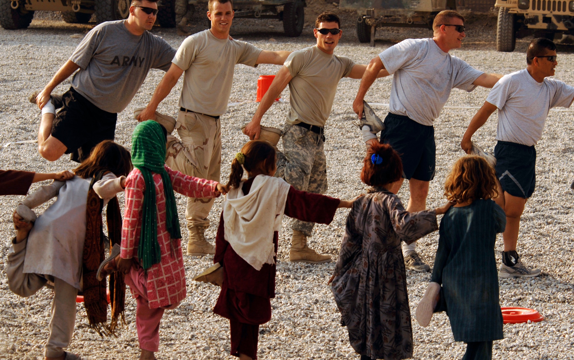 Army and Air Force members from the Nangarhar Provincial Reconstruction Team and Afghan children stretch before they play soccer together Nov. 9 at the PRT forward operating base in Jalalabad, Afghanistan. The Nangarhar PRT is a joint team of Airmen, Soldiers and representatives from the U.S. Department of State, U.S. Agency for International Development and the U.S. Department of Agriculture. The team is responsible for helping the Islamic Republic of Afghanistan government improve security, governance and promote reconstruction in the Nangarhar Province. PRT members assess community needs and then builds schools, government centers, roads, medical capability and basic infrastructure throughout Nangarhar. Unit members also mentor Afghan government officials and security forces to provide the Afghan people with the state representation and security they need. (U.S. Air Force photo/Staff Sgt. Joshua T. Jasper)
