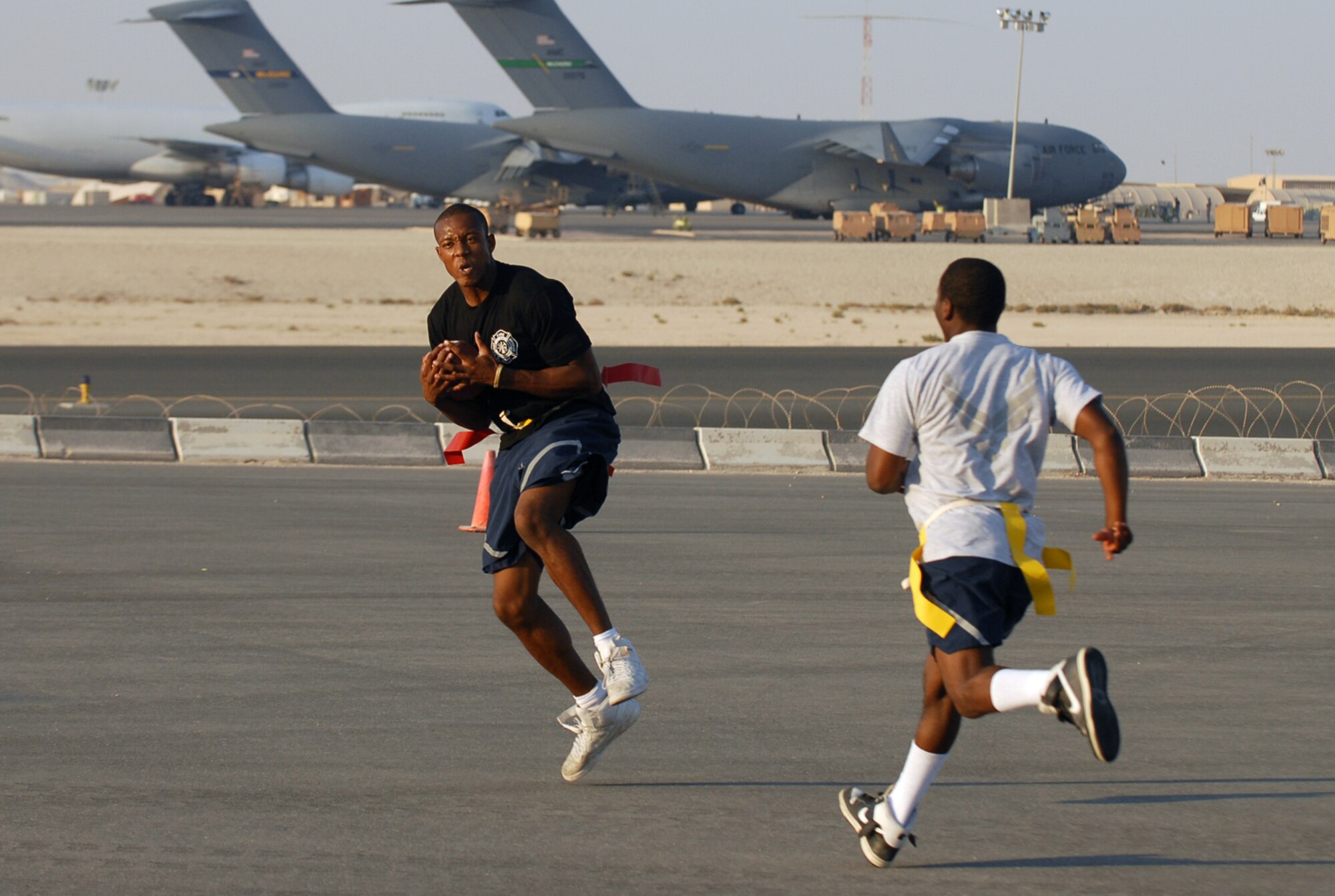 SOUTHWEST ASIA - Part of the Thanksgiving Day festivities at a Southwest Asia air base included a flag football game between the 379th Expeditionary Security Forces Squadron law enforcers and the 379th Expeditionary Civil Engineer Squadron  fire fighters. Airman 1st Class Kristopher Noel makes a reception for the fire fighters. (U. S. Air Force photo/Staff Sgt. Douglas Olsen)

