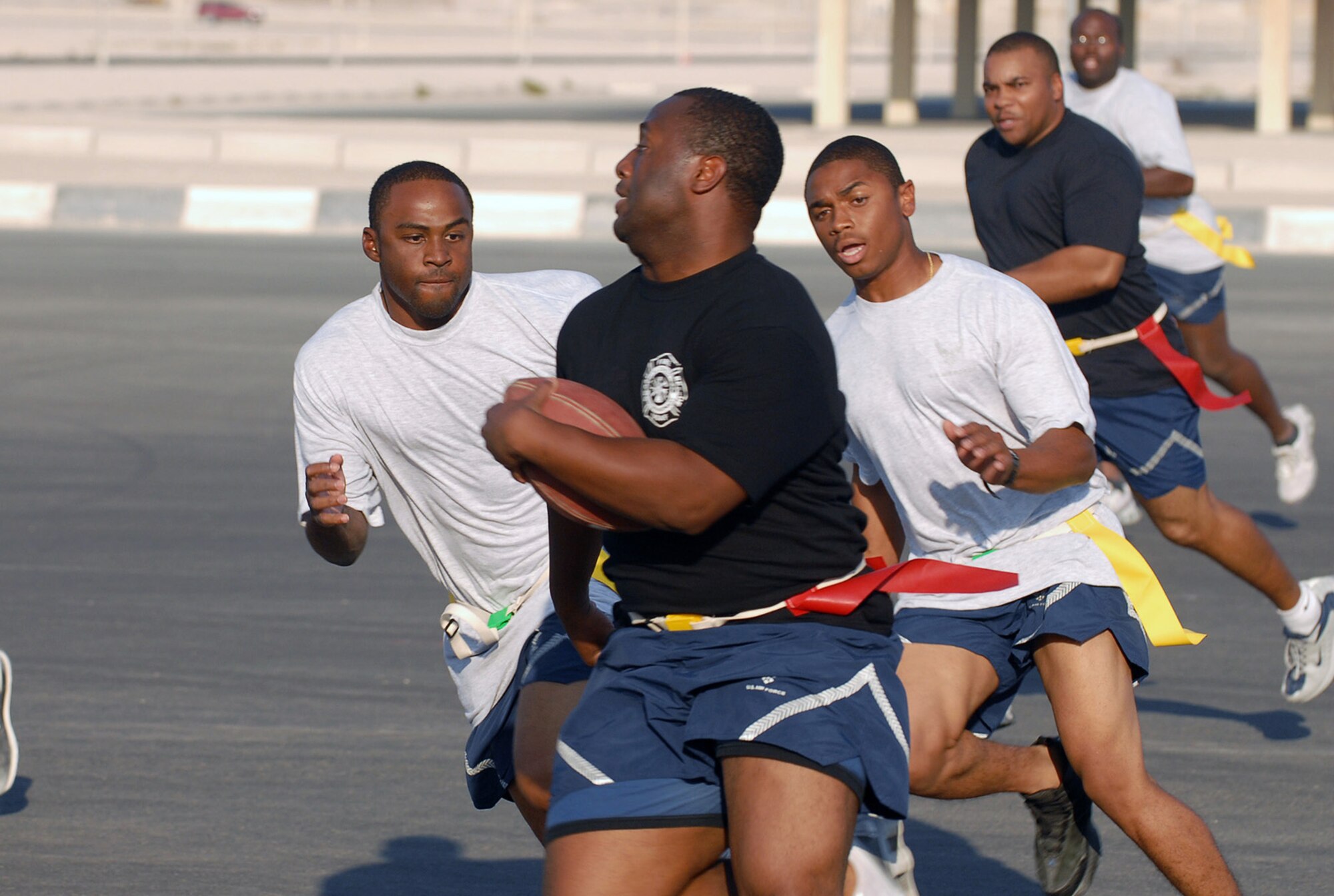 SOUTHWEST ASIA - Part of the Thanksgiving Day festivities at a Southwest Asia air base included a flag football game between the 379th Expeditionary Security Forces Squadron  law enforcers and the 379th Expeditionary Civil Engineer Squadron fire fighters. Senior Airman  Brandon Boggs and Staff Sgt. Johnny Truesdale, 379th ESFS, close in on Senior Airman Derrick Claytor, 379th ECES. (U. S. Air Force photo/Staff Sgt. Douglas Olsen)
