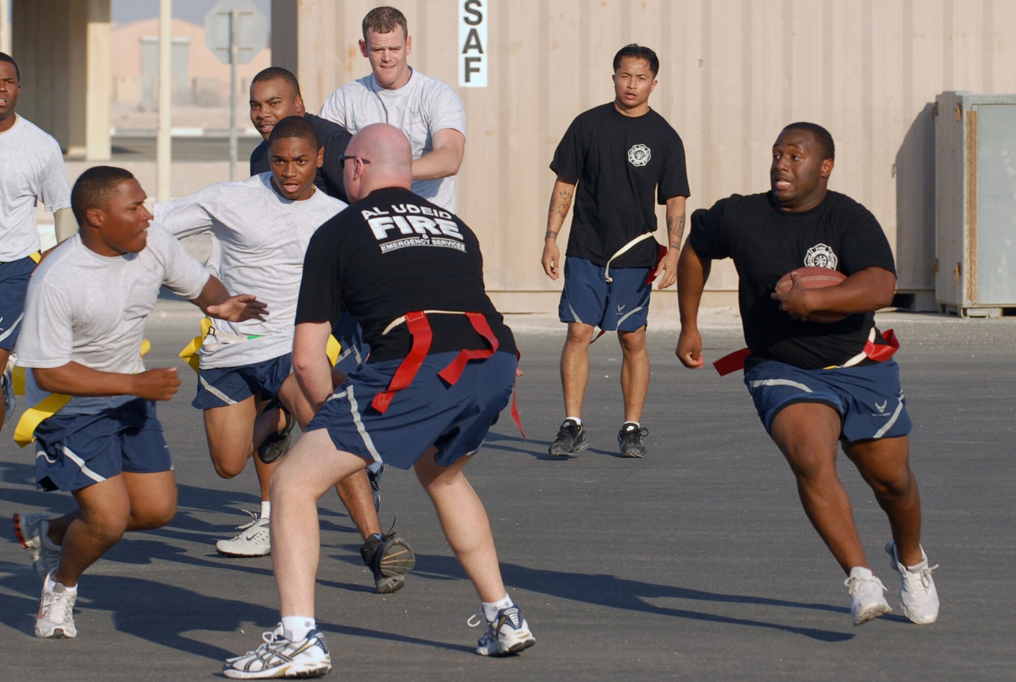SOUTHWEST ASIA - Part of the Thanksgiving Day festivities at a Southwest Asia air base included a flag football game between the 379th Expeditionary Security Forces Squadron law enforcers and the 379th Expeditionary Civil Engineer Squadron  fire fighters. Senior Airman Derrick Claytor, 379th ECES, evades the 379th ESFS players with help from his teammates. (U. S. Air Force photo/Staff Sgt. Douglas Olsen)

