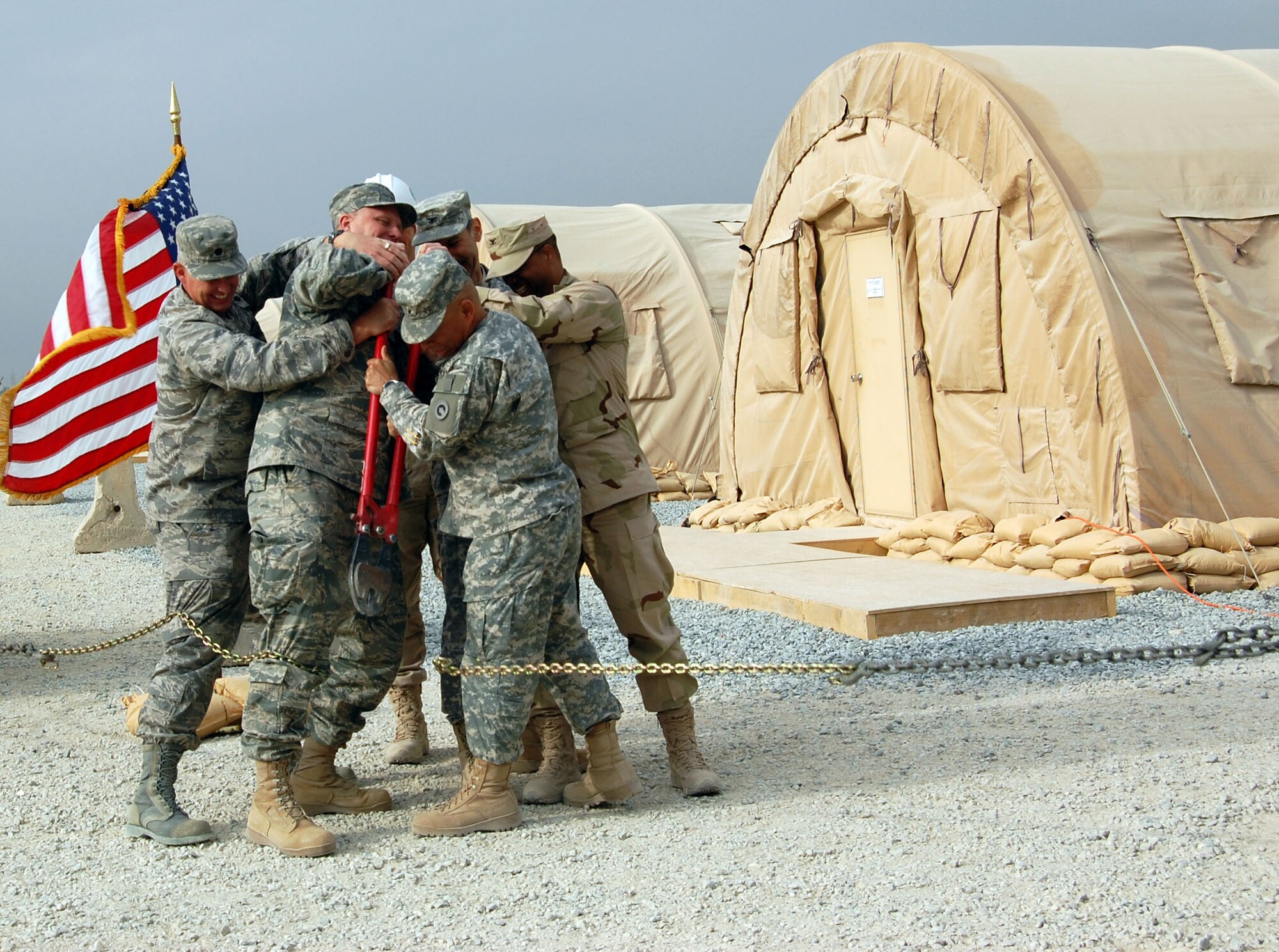 SOUTHWEST ASIA – A group of commanders work together to cut a chain Nov. 24 at Camp Arifjan, Kuwait. The ceremony marked the grand opening of the new convoy support center. (Air Force photo\Staff Sgt. Phillip Butterfield)


