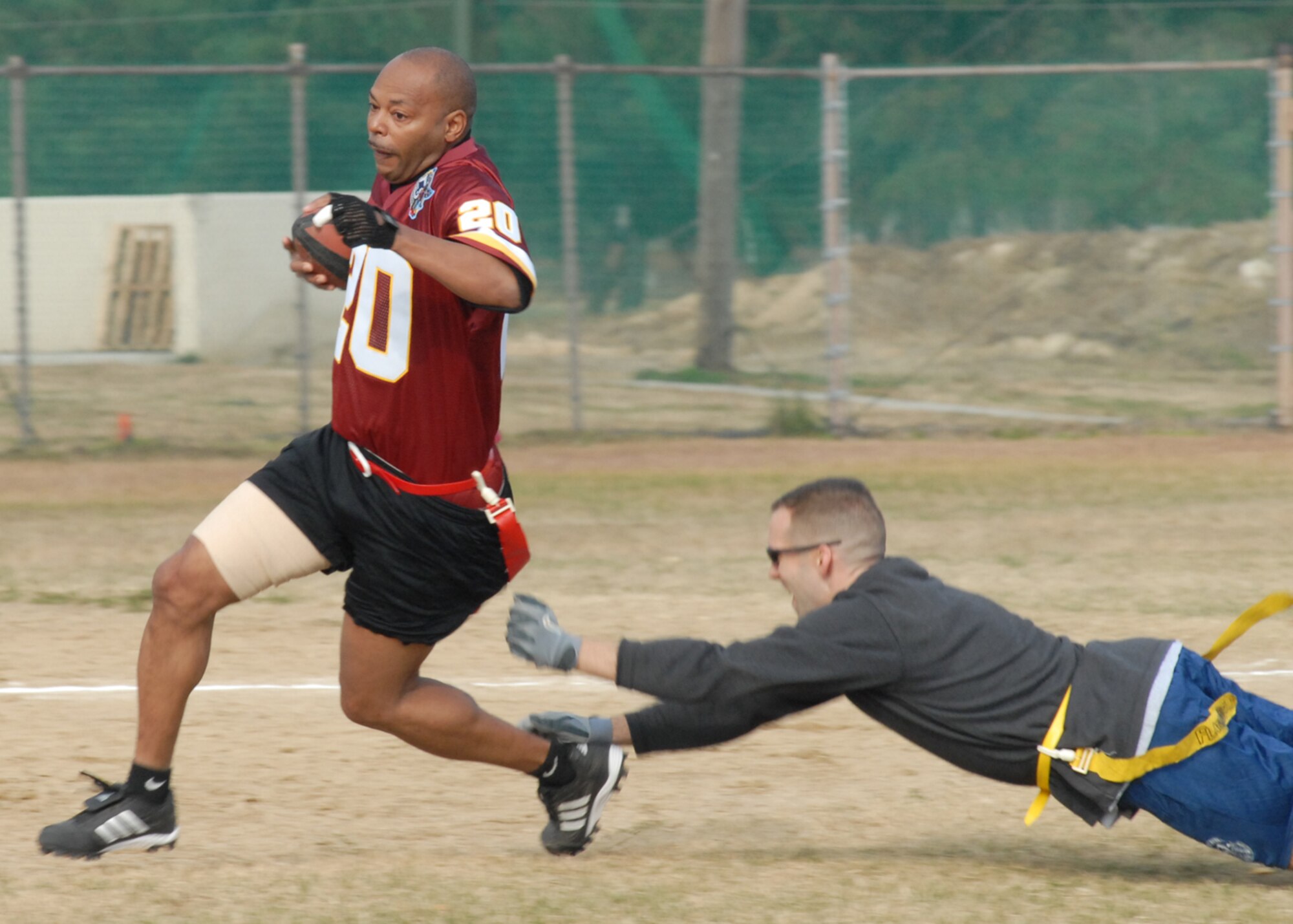 KUNSAN AIR BASE, South Korea—  Chief Master Sgt. Albert Turner, 8th Mission Support Group, avoids getting his flag removed by Maj. Mark Henry, 8th Communications Squadron commander, here Nov. 23. The chiefs won the game 20 to 6 against the commanders. The game is one of several sporting competitions between the two groups that have taken place during the course of the year.  (U.S. Air Force Photo/Staff Sgt. Araceli Alarcon) 