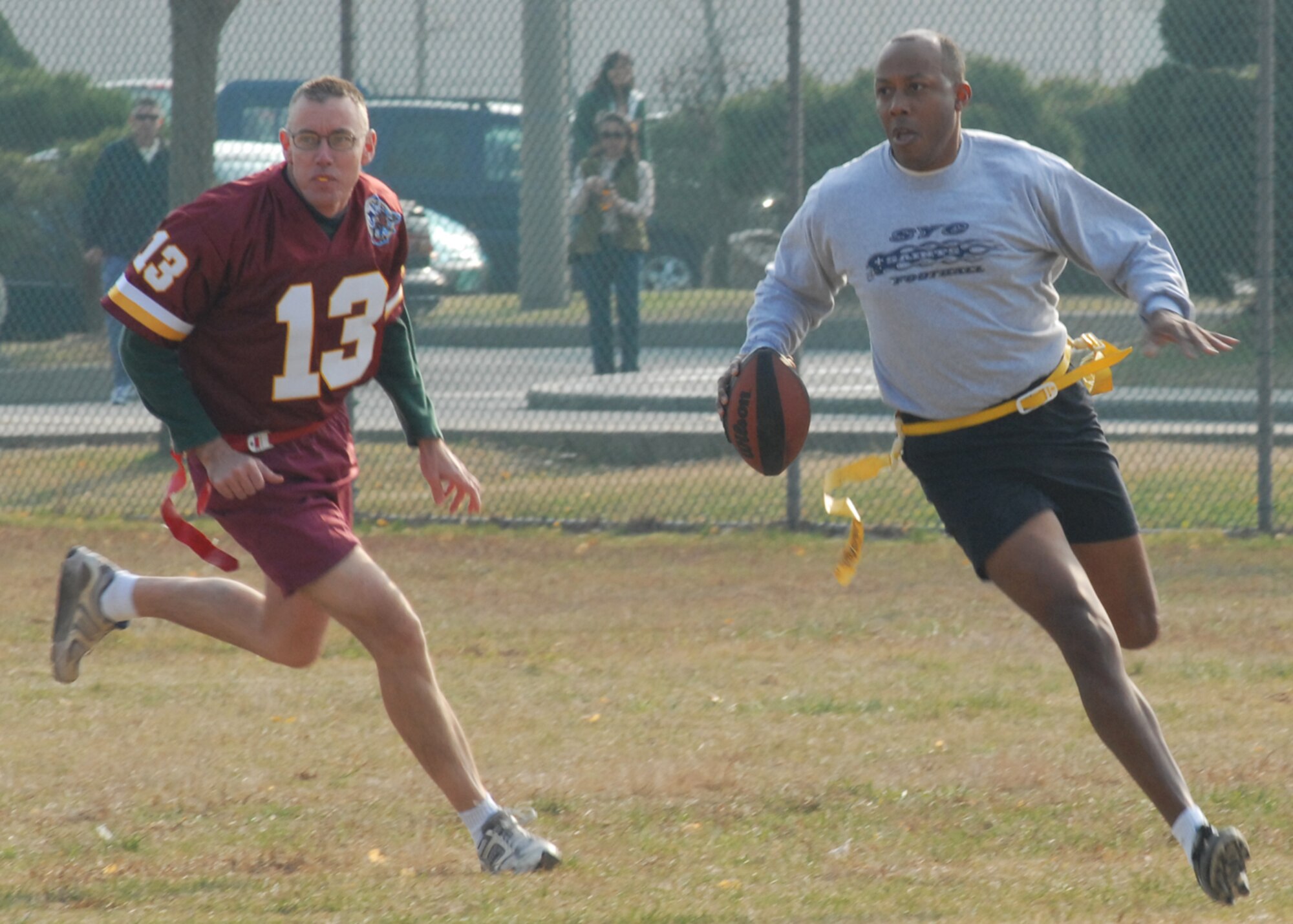 KUNSAN AIR BASE, South Korea—  Chief Master Sgt. David Scott, 8th Communications Squadron, chases Col. CQ “Wolf” Brown, 8th Fighter Wing commander, causing a lost in yards here Nov. 23. The Chiefs won the game 20 to 6 against the commanders. The game is one of several sporting competitions between the two groups that have taken place during the course of the year.  (U.S. Air Force Photo/Staff Sgt. Araceli Alarcon)