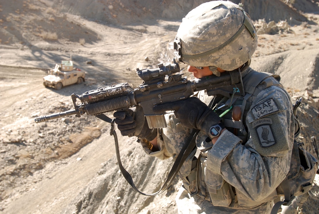 A U.S. paratrooper scans the low ground while providing security for a convoy passing through the mountains of Paktika province, Afghanistan, Nov. 10, 2007. The soldier is assigned to the 173rd Airborne Brigade Combat Team's 1st Battalion, 503rd Infantry Regiment.
