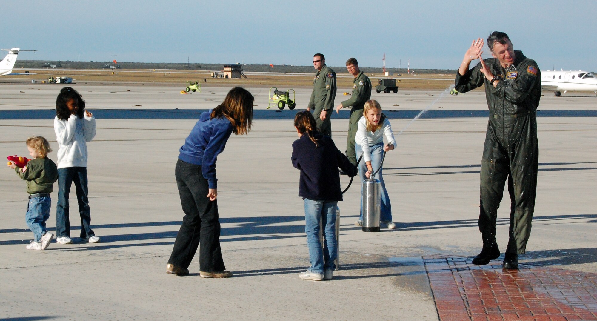 LAUGHLIN AIR FORCE BASE, Texas – Nicole and Sarah Minahan give Col. Mike Minahan, 47th Flying Training Wing commander, a salutatory shower after his final flight Nov. 26 Colonel Minahan was recently selected as Executive Officer to U.S. European Command Deputy Commander Vice Admiral Richard Gallagher at USEUCOM Headquarters in Stuttgart, Germany. Col. Minahan will soon depart Laughlin for Germany after almost two years of command. (U.S. Air Force photo by Senior Airman Olufemi Owolabi)
