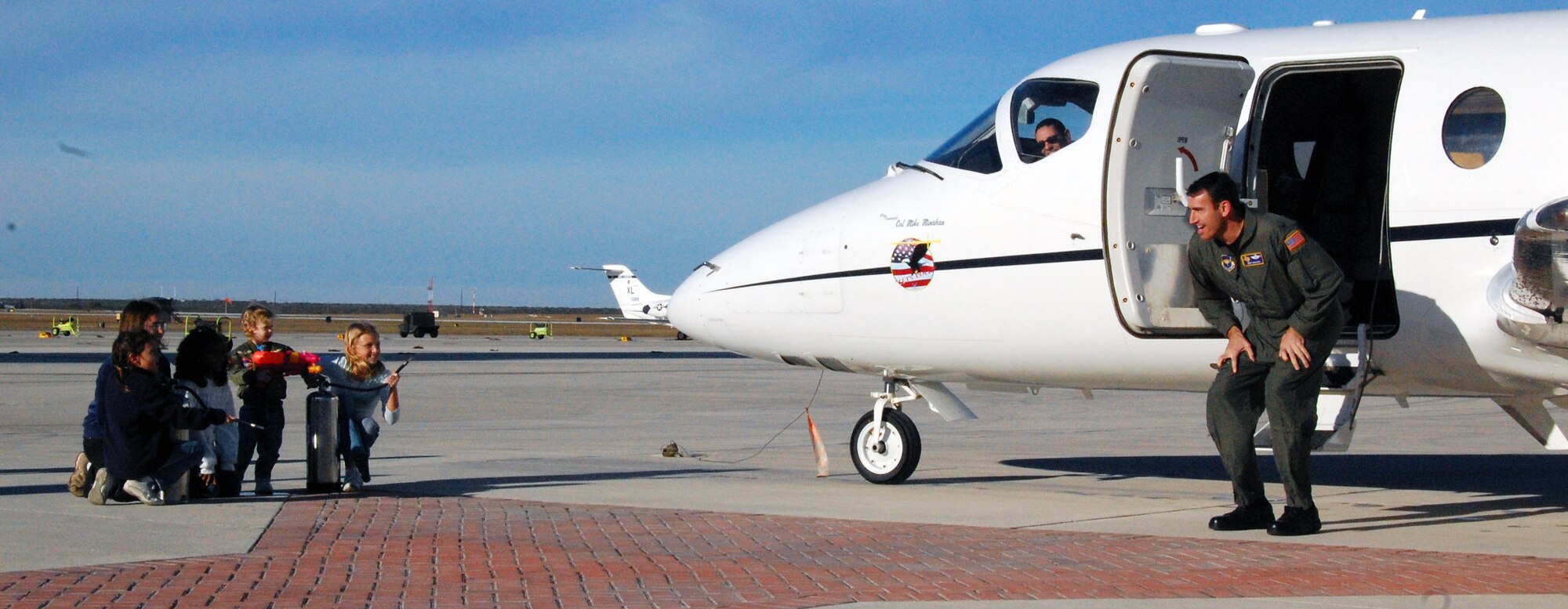 LAUGHLIN AIR FORCE BASE, Texas – Nicole and Sarah Minahan and their friends await Col. Mike Minahan’s arrival before giving him a salutatory shower after his final flight here Nov. 26.  Colonel Minahan, 47th Flying Training Wing commander, was recently selected as Executive Officer to U.S. European Command Deputy Commander Vice Admiral Richard Gallagher at USEUCOM Headquarters in Stuttgart, Germany. Col. Minahan will soon depart Laughlin for Germany after almost two years of command. (U.S. Air Force photo by Senior Airman Olufemi Owolabi)