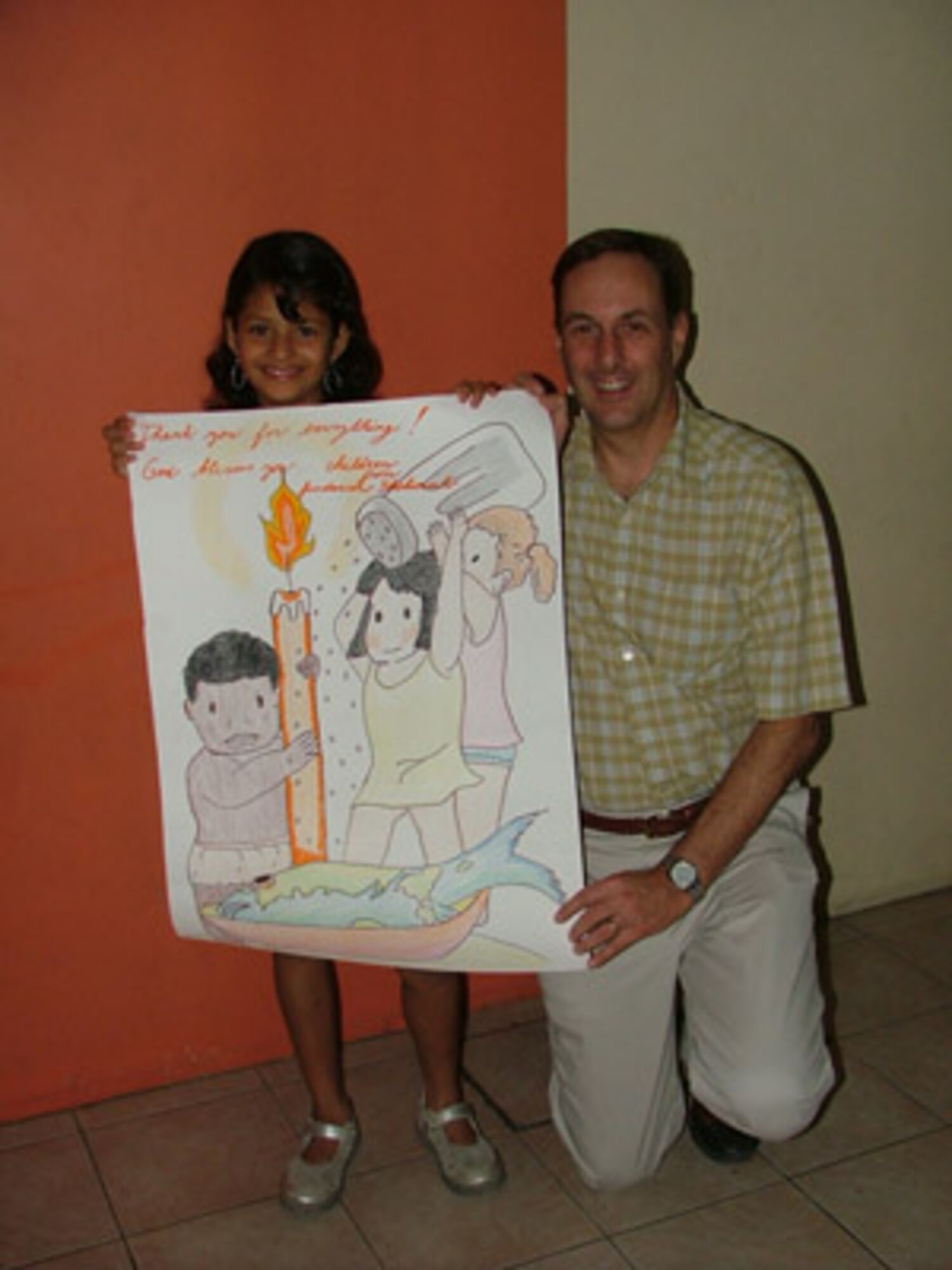 Maj. Gen. Craig Campbell, Alaska State Adjutant General, stands with a child at Shekinah Orphanage during his visit to Manta, Ecuador.  The children presented him with a poster expressing their gratitude for the donations that he, as well as the members from the 168th ARW, made during their time here in Manta. (U.S. Air Force photo/1st Lt. Malinda Singleton) 