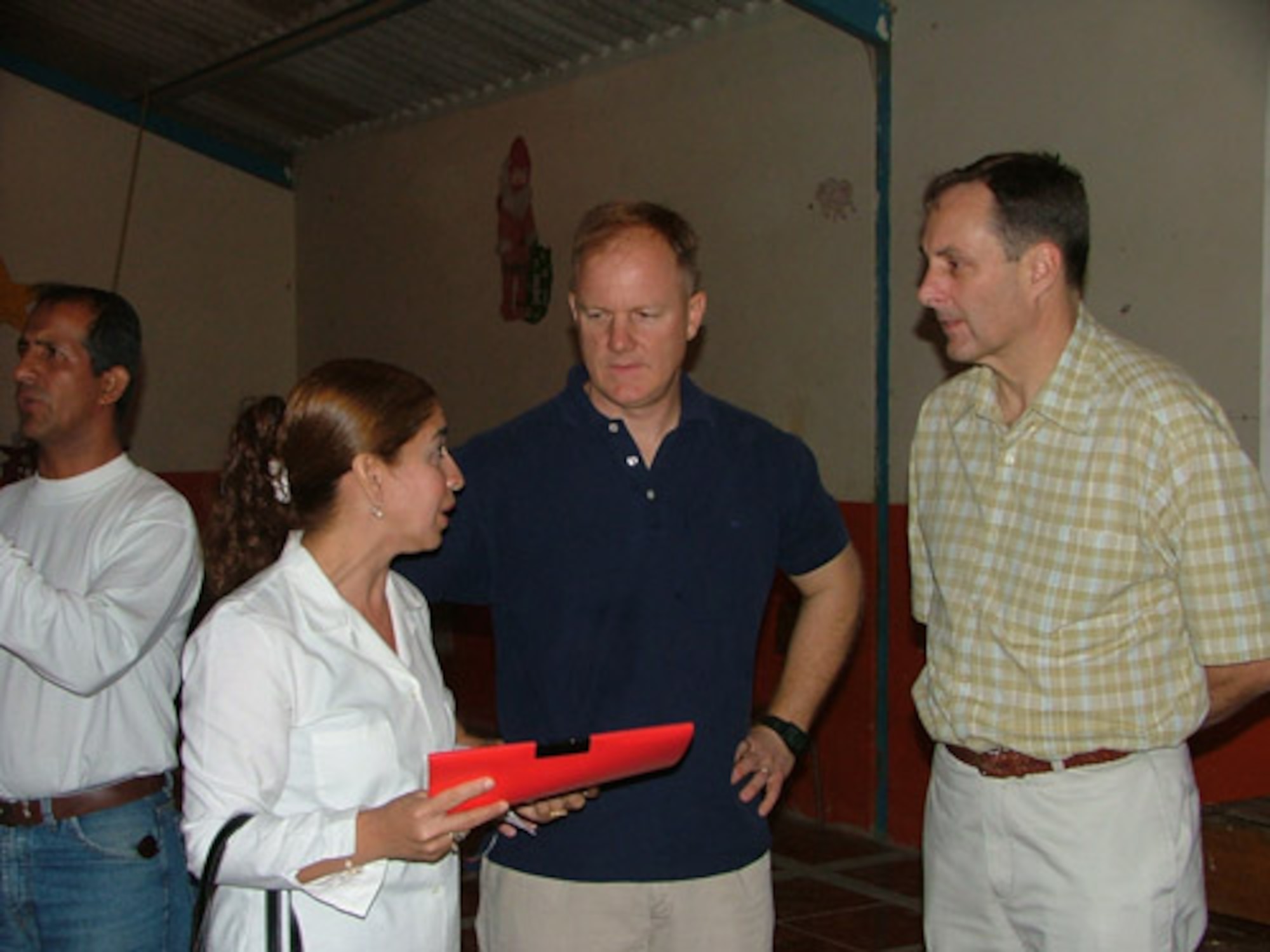 Maj. Gen. Craig Campbell, Alaska State Adjutant General, and Lt. Col. Mark Dewey, 168th Air Refueling Wing detachment commander, talk with Dra. Mayra Velez Lopez, while visiting Comedor De Divino Niños, which is a “soup kitchen” in Manta, Ecuador.  Earlier, Maj. Gen. Campbell presented Dra. Lopez with a pledge for $405 to buy two doors and three windows for the soup kitchen. (U.S. Air Force photo/1st Lt. Malinda Singleton)