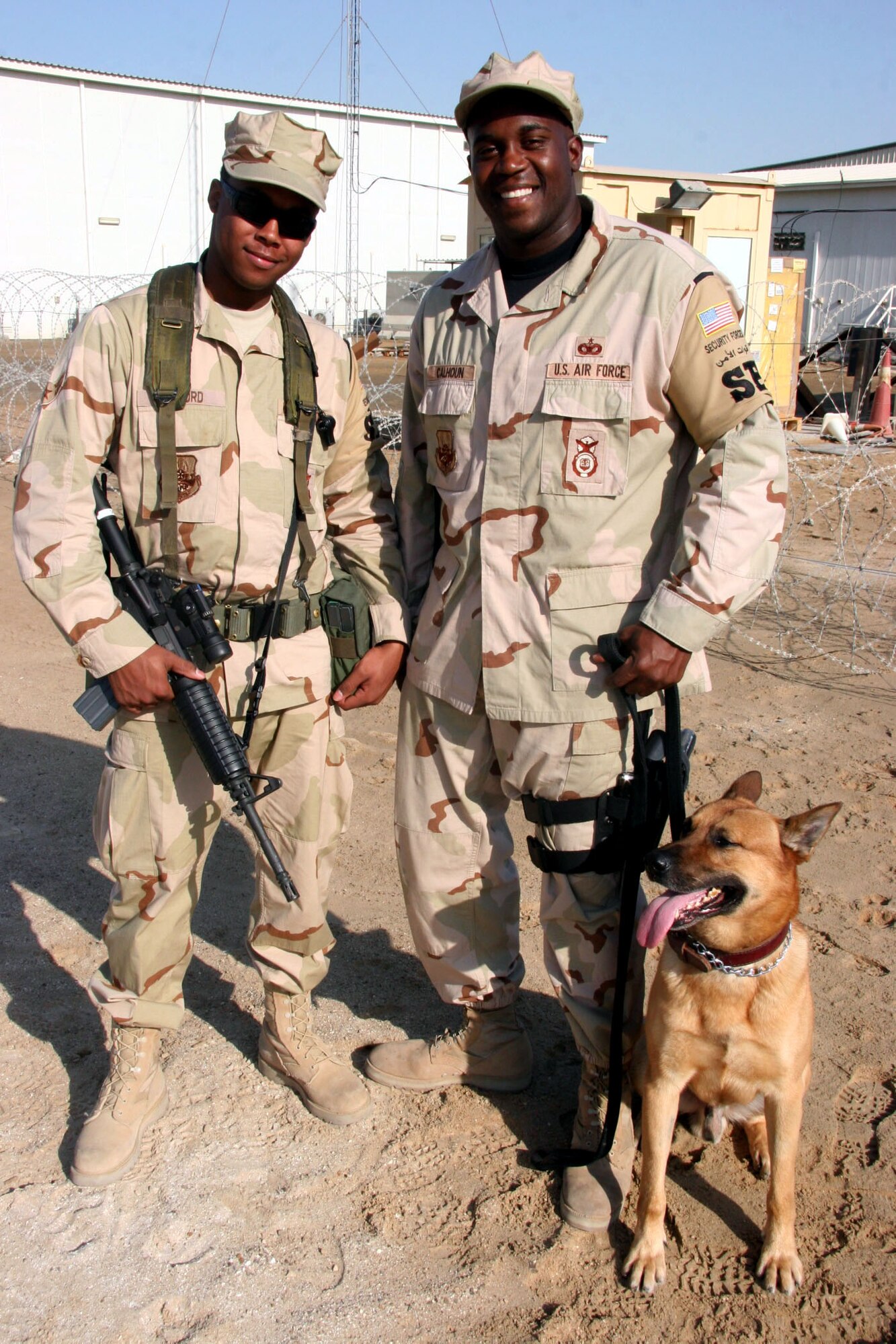 Airman 1st Class Dandre Bufford and Staff Sgt. Malik Calhoun are brothers assigned to the 380th Expeditionary Security Forces Squadron, Southwest Asia. Sergeant Calhoun, who is a K-9 handler deployed from the 52nd Security Forces Squadron, Spangdahlem Air Base, Germany, surprised his little brother Airman Bufford, who is deployed from the 31st SFS, Aviano Air Base, Italy, Nov. 21, when they were reunited after being separated from more than two years. (U.S. Air Force photo/Master Sgt. Ruby Zarzyczny) 
