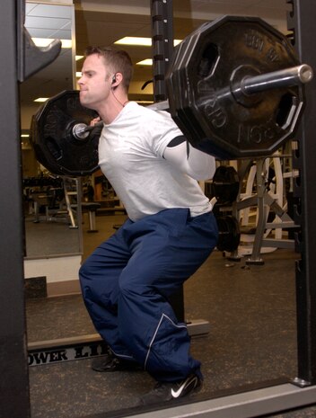 Senior Airman Ryan Michaels is squatting 270 lbs at the Nellis gym. Airman Michaels has been doing sports since a young age. His father was his first trainer and now he works out with Staff Sgt. Steven Potts, an area supervisor with the 99th Security Support Squadron, who has been his training partner for five years now. (Air Force photo by Airman 1st Class Oleksandra G. Manko)