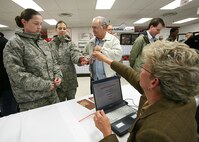 Nancy Conley checks the identification card of Trainee Rachel Cirell before Glen Johnson, a repeat adopter during Operation Homecooking, can take Trainees Cirell and Britany Williamson home for Thanksgiving dinner. The trainees are assigned to the 320th Training Squadron, Flight 058. Mr. Johnson has hosted trainees for 15 years. (USAF photo by Robbin Cresswell)