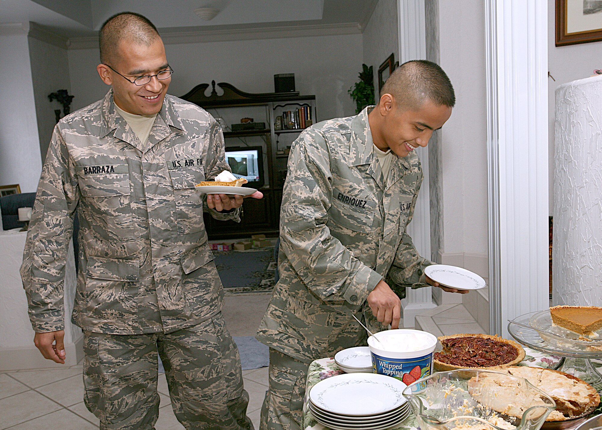 Air Force Trainees Ublabo Barraza, left, and Keno Enriquez have a choice of pumpkin, apple and pecan pies during Thanksgiving dinner at Master Sgt. Tammi and Tech. Sgt. Roy Barnett's home in San Antonio, Texas. The trainees are assigned to the 331st Training Squadron, Flight 065. Sergeant Tammi Barnett works in the 340th Flying Training Group at Randolph AFB. Sergeant Roy Barnett is assigned to the Air Force Personnel Center at Randolph AFB. (USAF photo by Robbin Cresswell)