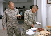 Air Force Trainees Ublabo Barraza, left, and Keno Enriquez have a choice of pumpkin, apple and pecan pies during Thanksgiving dinner at Master Sgt. Tammi and Tech. Sgt. Roy Barnett's home in San Antonio, Texas. The trainees are assigned to the 331st Training Squadron, Flight 065. Sergeant Tammi Barnett works in the 340th Flying Training Group at Randolph AFB. Sergeant Roy Barnett is assigned to the Air Force Personnel Center at Randolph AFB. (USAF photo by Robbin Cresswell)