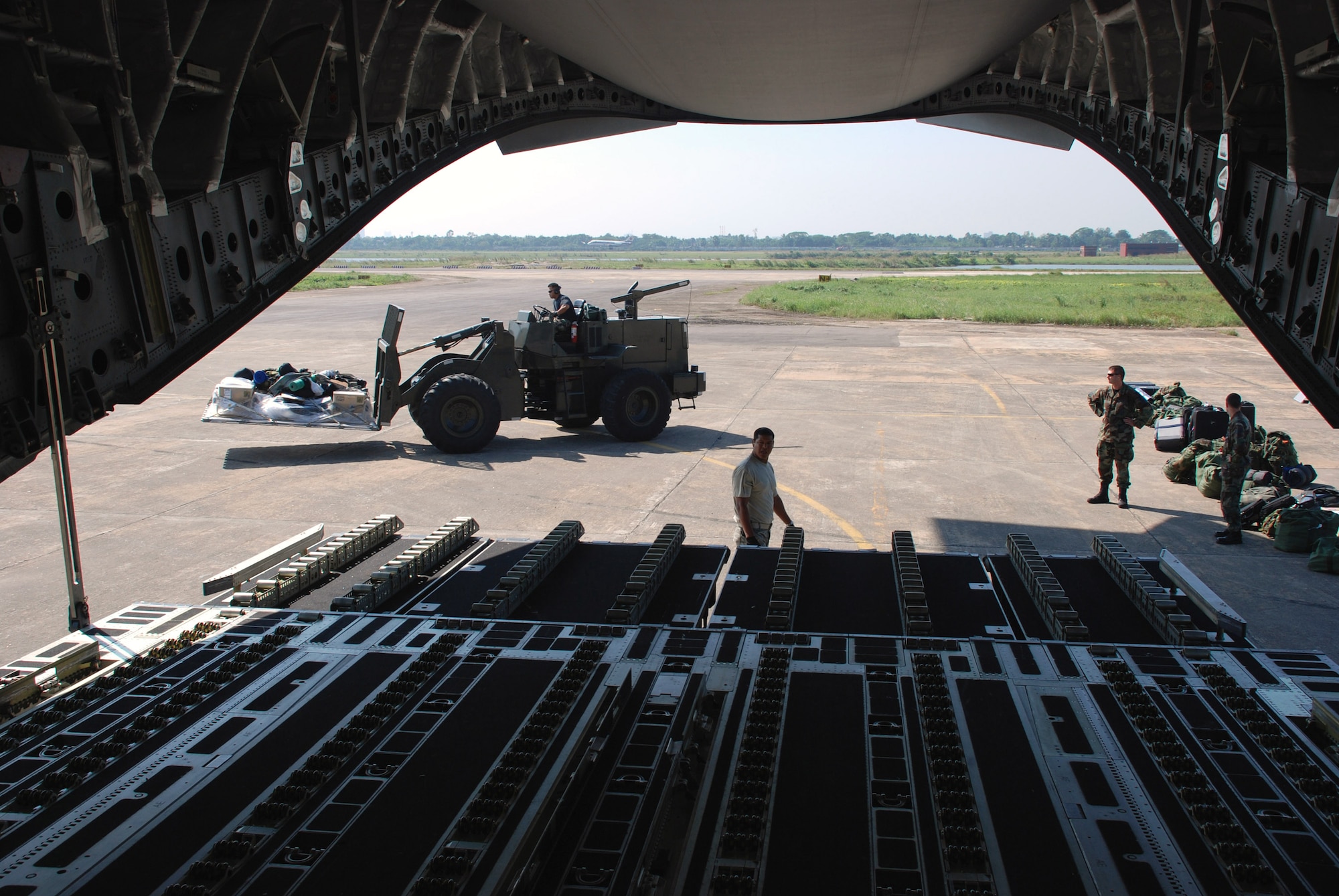 A 37-person team from the 36th Contingency Response Group from Andersen Air Force Base, Guam, offload a C-17 Globemaster III Nov. 26 at Zia International Airport in Dhaka, Bangladesh. A 13th Air Force-led mission employed the C-17 to bring the 36th CRG Airmen to Bangladesh where they will establish relief supply transload operations in the wake of a Nov. 15 tropical cyclone that devastated much of the southern part of the country. The C-17 and crew are from Hickam AFB, Hawaii. (U.S. Air Force photo/1st. Lt. Michael Boyer) 
