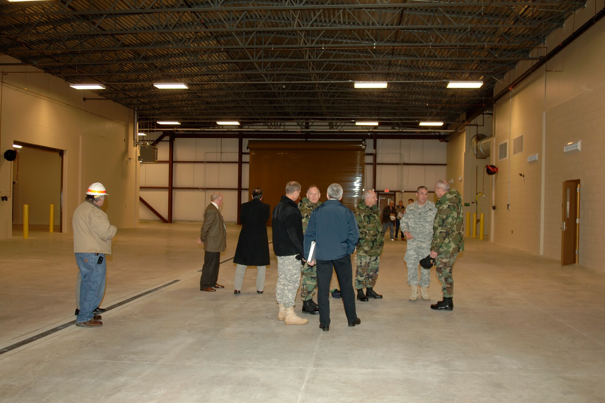 HANSCOM AFB, Mass. -- Base leadership survey the newly constructed, 18,000 square-foot Heavy Repair Equipment facility Nov. 20. This $3.9 million building will serve as the central point for snow removal and grounds maintenance operations assigned to the Base Civil Engineer Heavy Repair Section. (U.S. Air Force photo by Jan Abate.)