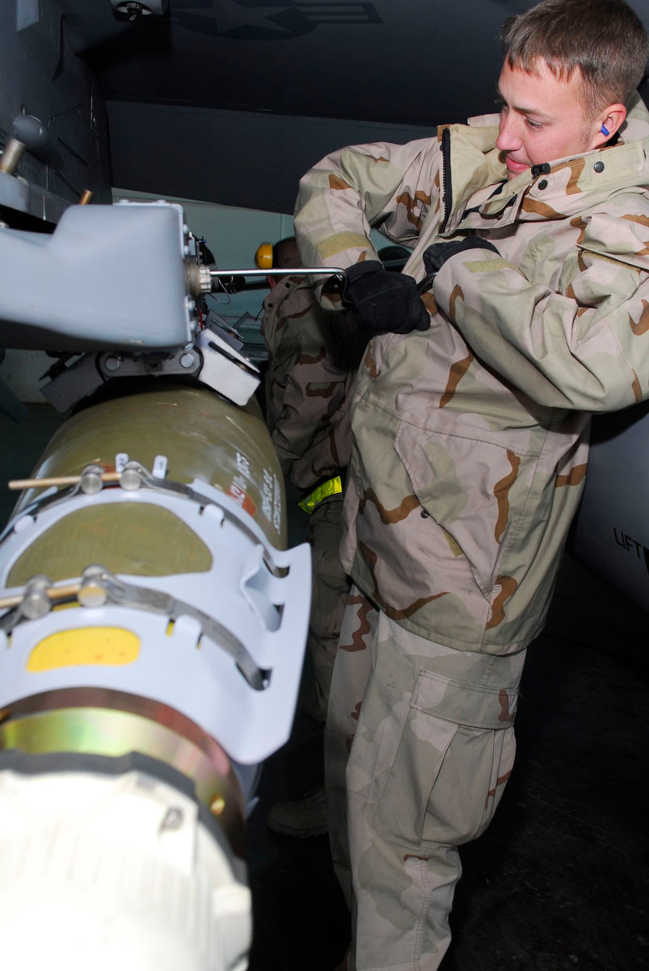 BALAD AIR BASE, Iraq -Senior Airman Ricky Howard, a 332nd Expeditionary Aircraft Maintenance Squadron Aircraft Maintenance Unit weapons loader, unscrews impulse carts while de-arming an F-16 Fighting Falcon here, Nov. 27. The carts are used to deploy the bombs from the aircraft. Airman Howard is deployed from Hill Air Force Base, Utah. (U.S. Air Force photo/Staff Sgt. Joshua Garcia)