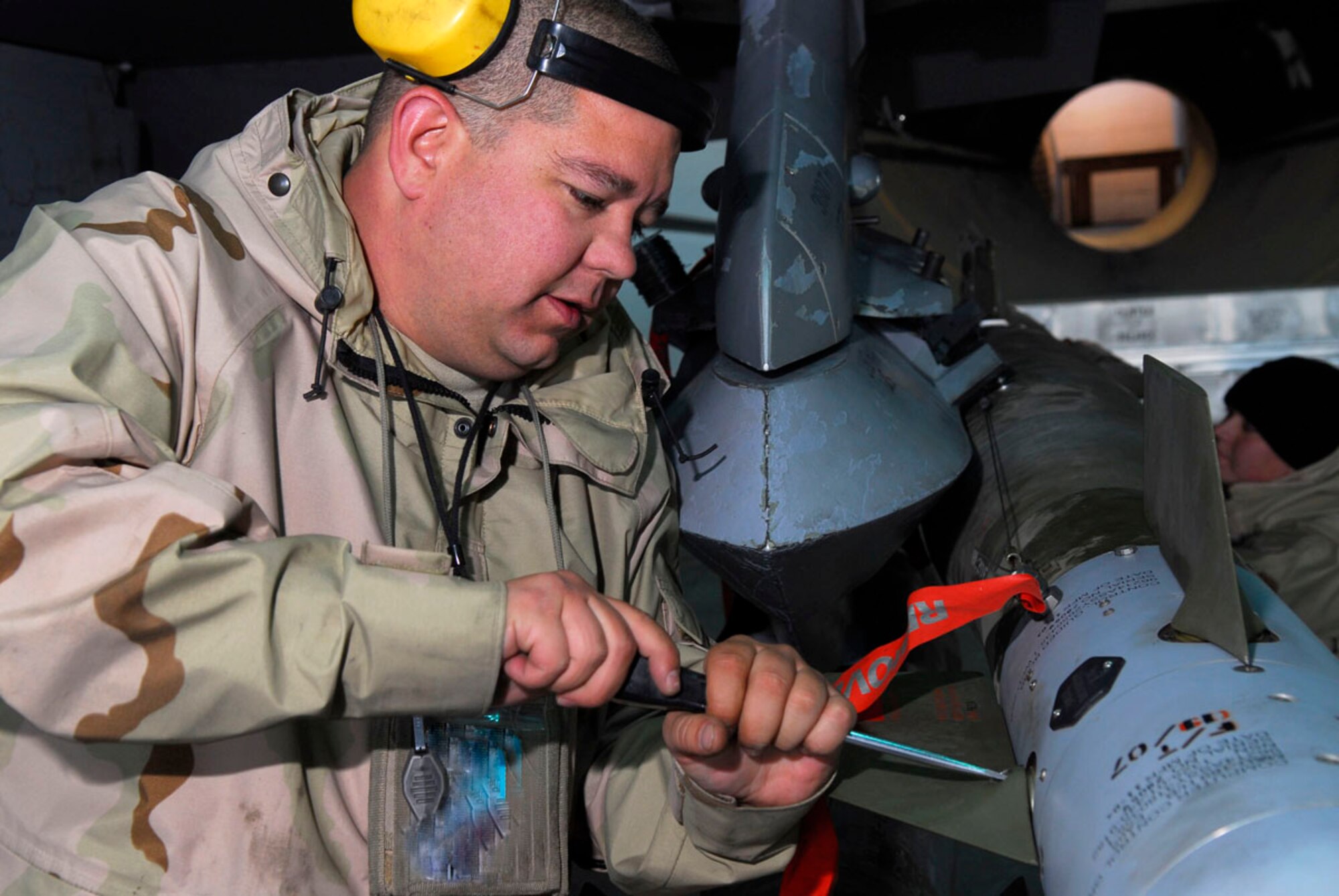 BALAD AIR BASE, Iraq -- Staff Sgt. Jeremiah Lagestam, a 332nd Expeditionary Aircraft Maintenance Squadron Aircraft Maintenance Unit weapons loader, secures the tailfins of a Guided Bomb Unit 13 here, Nov. 27. The GBU-13 is one of the three main munitions used by the fighter squadrons here. Sergeant Lagestam is deployed from Hill Air Force Base, Utah. (U.S. Air Force photo illustration/Staff Sgt. Joshua Garcia)
