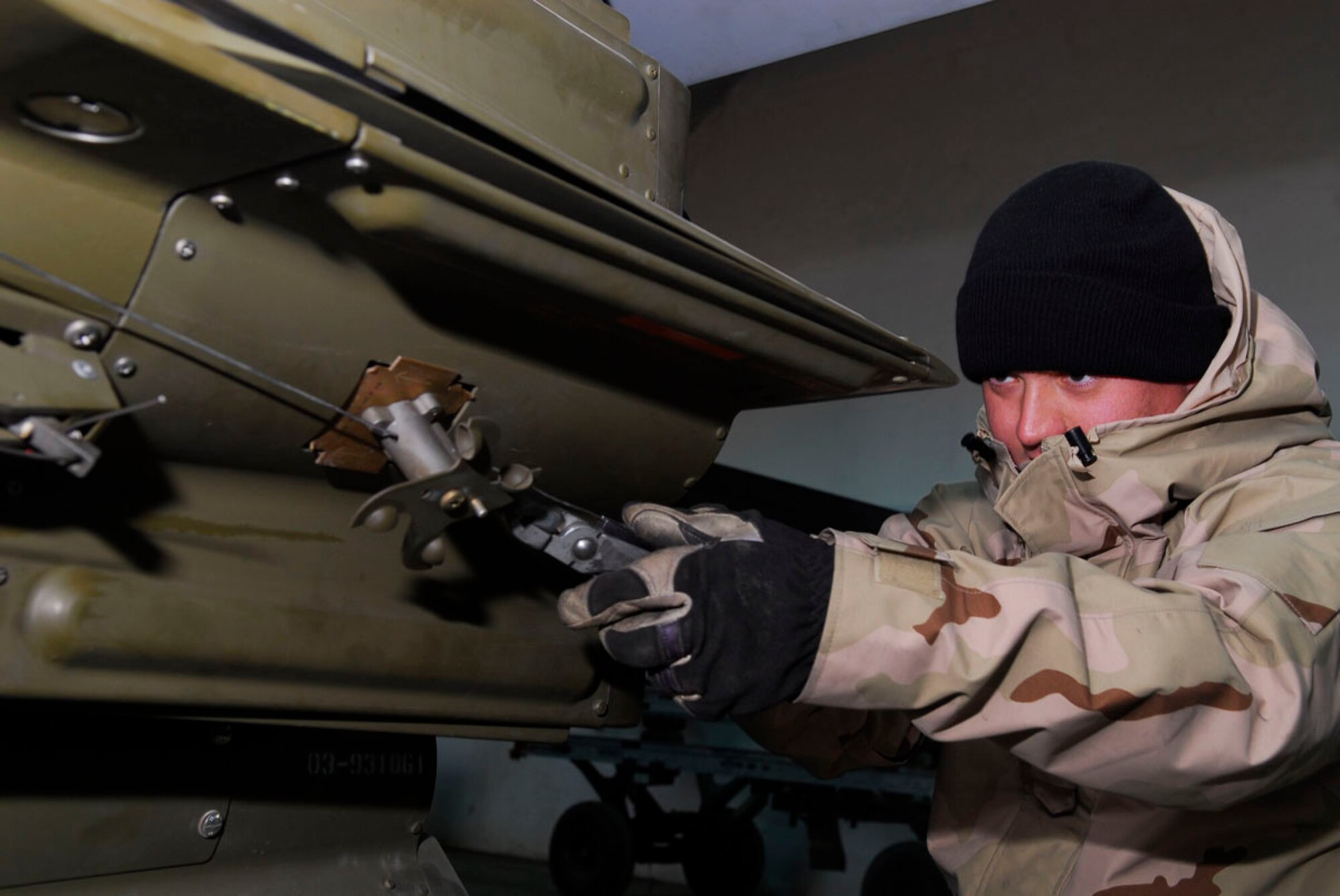 BALAD AIR BASE, Iraq -- Senior Airman Conrad Hughes, a 332nd Expeditionary Aircraft Maintenance Squadron Aircraft Maintenance Unit weapons loader, cuts a lanyard wire after securing a weapons unit to an F-16 Fighting Falcon here, Nov. 27. The weapons loaders are responsible for loading and unloading all munitions on Air Force aircraft launching missions from the base. Airman Hughes is deployed from Hill Air Force Base, Utah. (U.S. Air Force photo/Staff Sgt. Joshua Garcia)