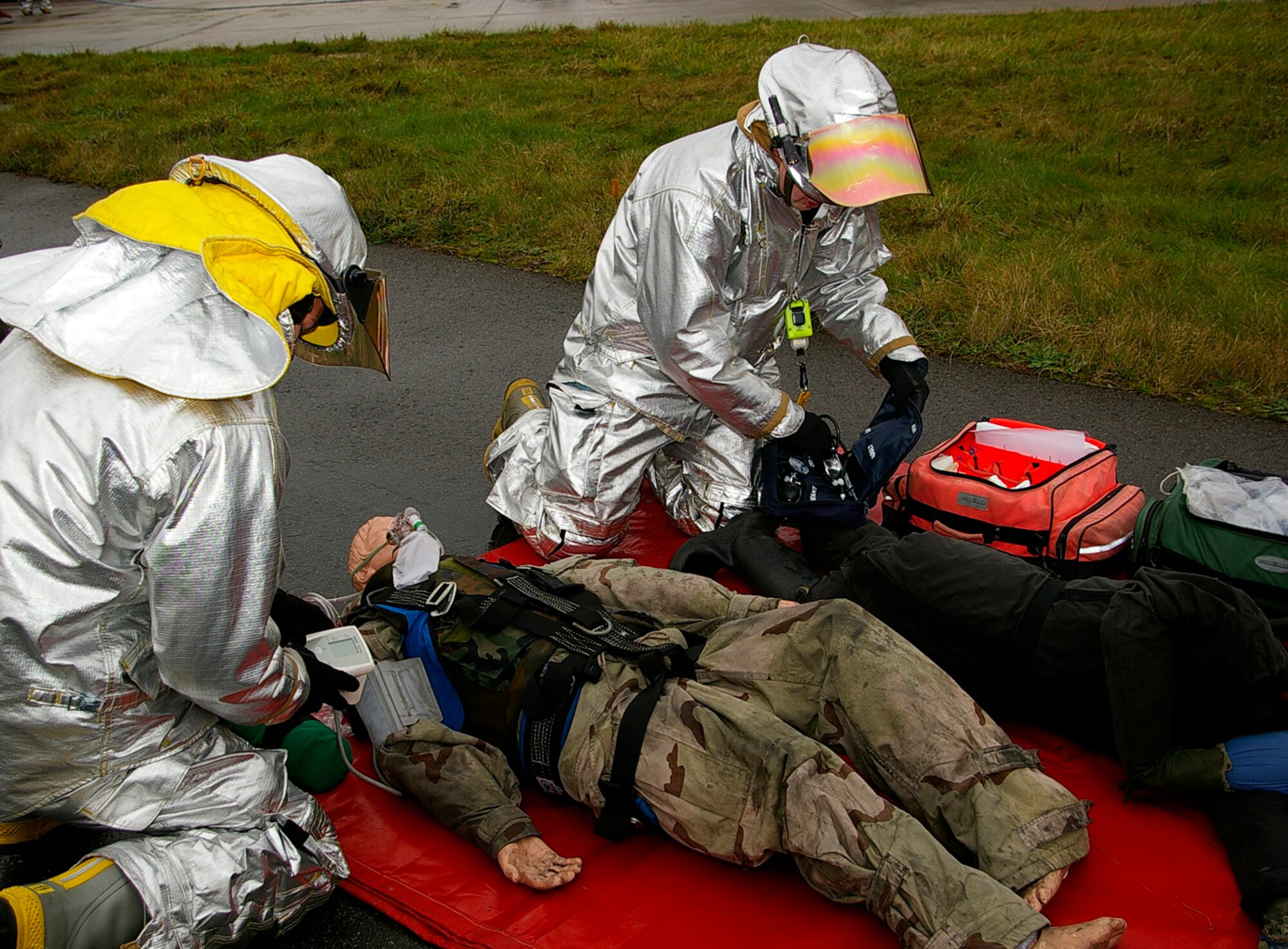 Airman 1st Class Scott May, left and Firefighter Simon Evans, both 100th Civil Engineer Squadron fire Department, simulate emergency care of an "injured person" during a training exercise on the southside of base. The exercise consisted of a simulated aircraft engine fire with two people unaccounted for. (U.S. Air Force photo by Karen Abeyasekere)